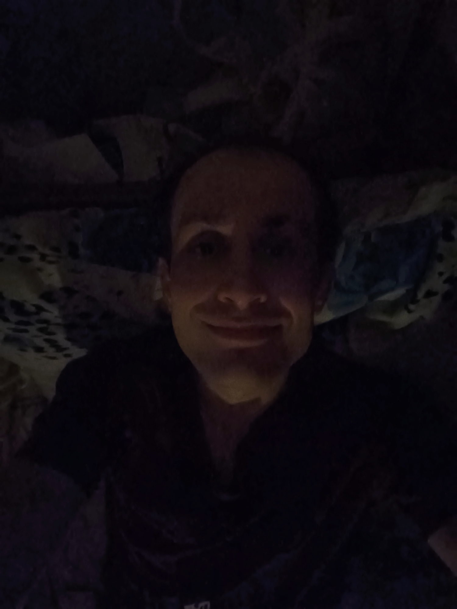 Late-night bedroom selfie session with dim lighting and a tapestry backdrop