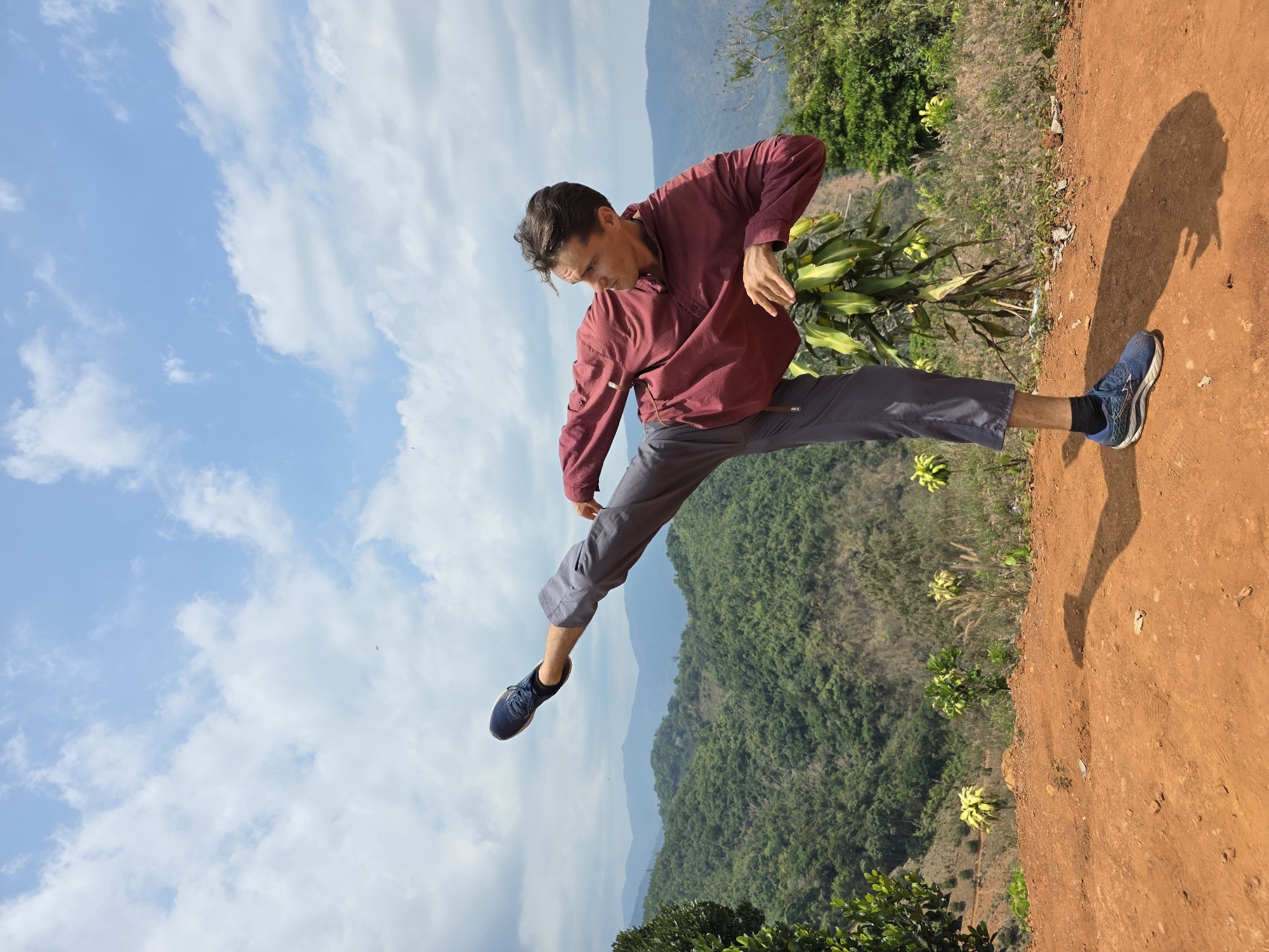 Man performs martial arts kicks on mountain overlook in Vietnam