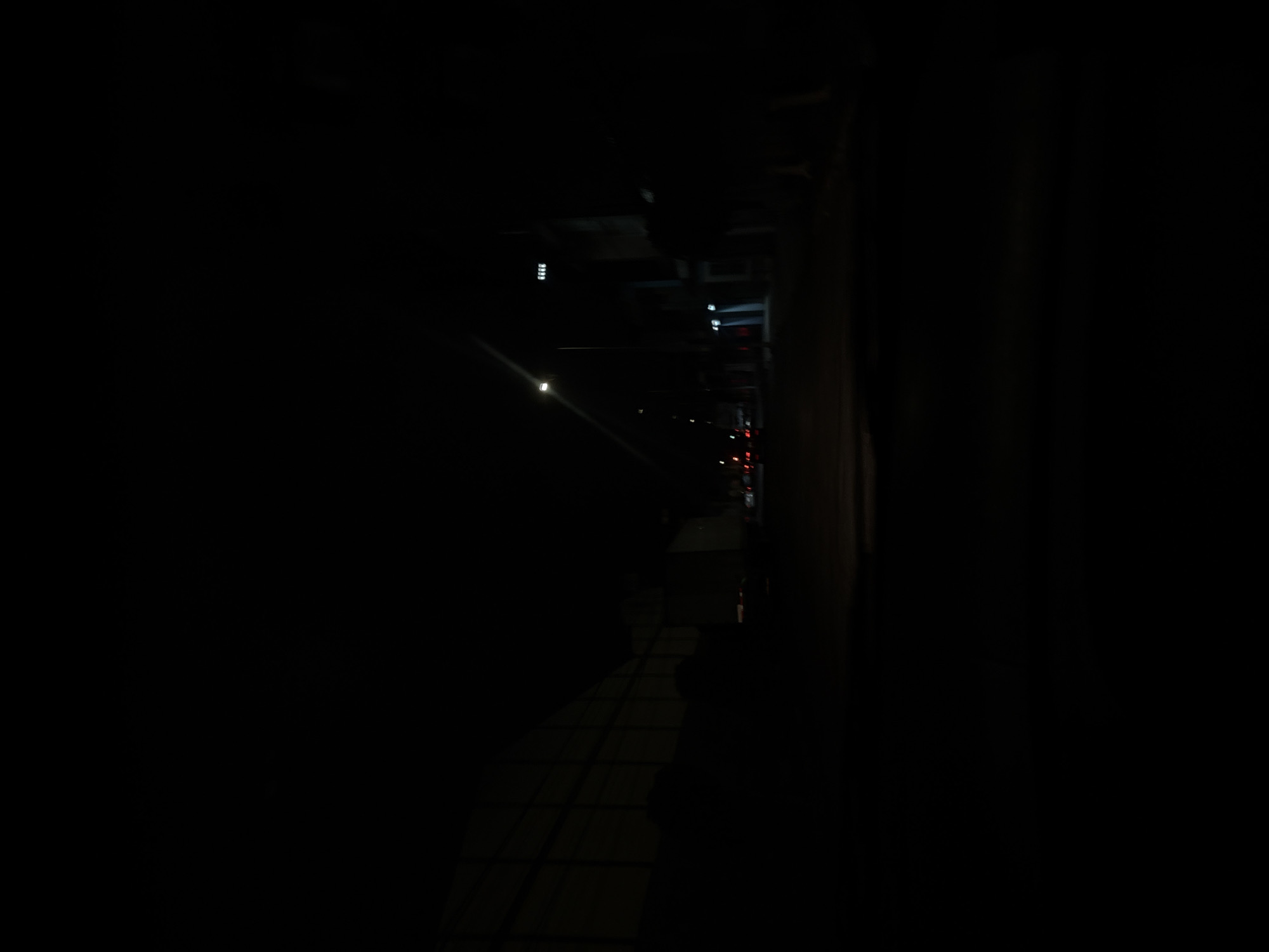 Night documentation of quiet urban alleyway with paved walkway