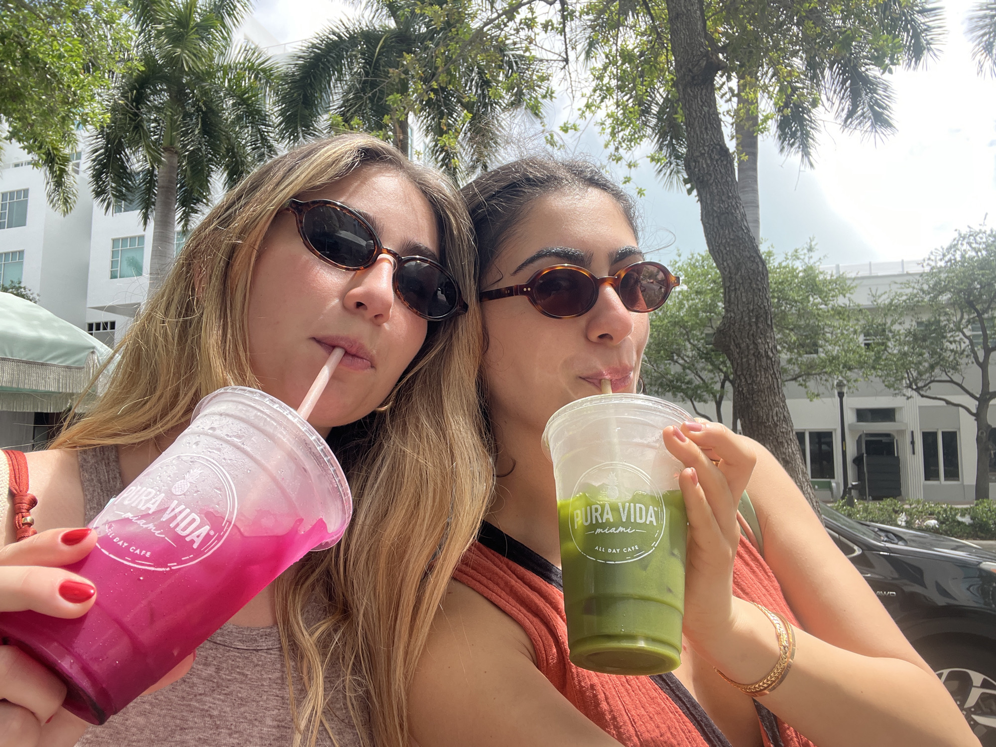 Two women enjoy drinks from Miami Beach cafe