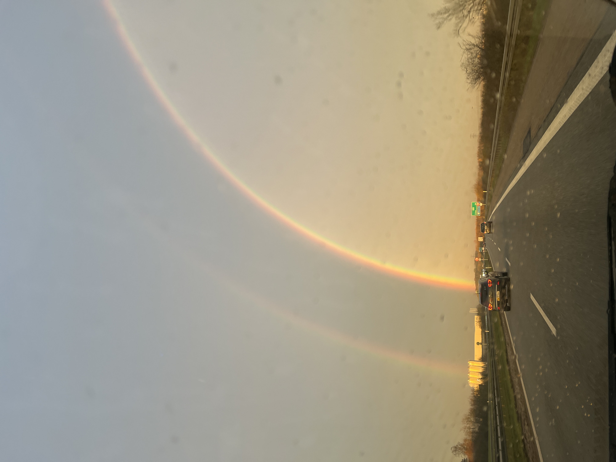 Double rainbow appears over highway in Rebild, Denmark