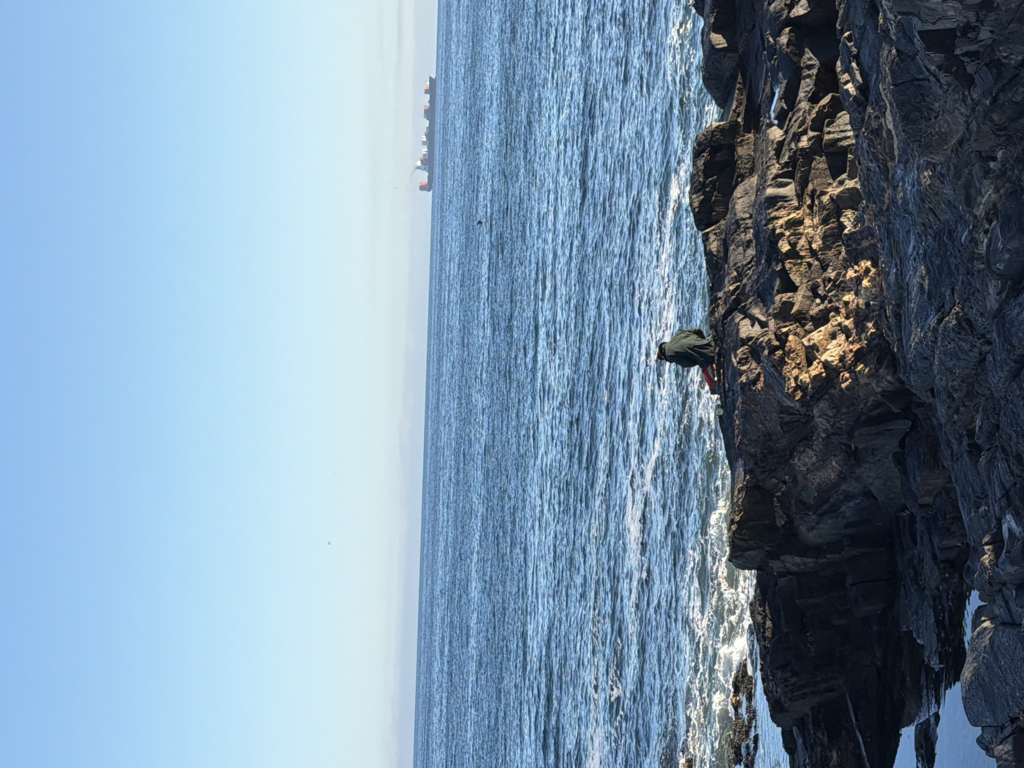Person stands on Cape Town clifftop overlooking ocean Saturday morning
