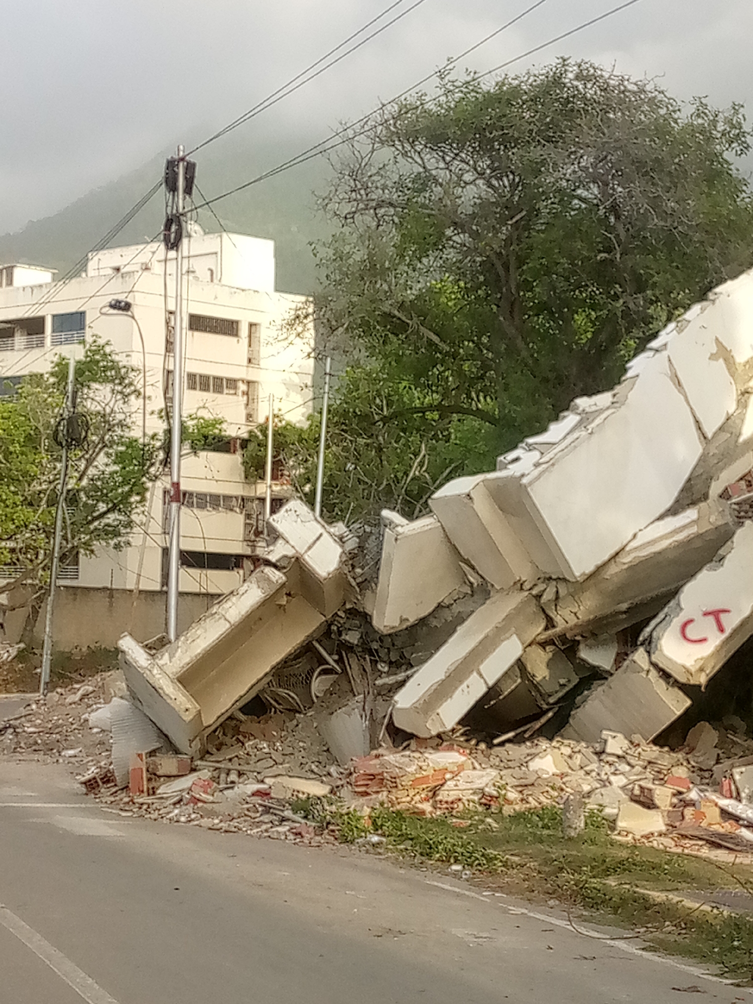 Debris and bulldozer at collapsed structure site in Caraballeda