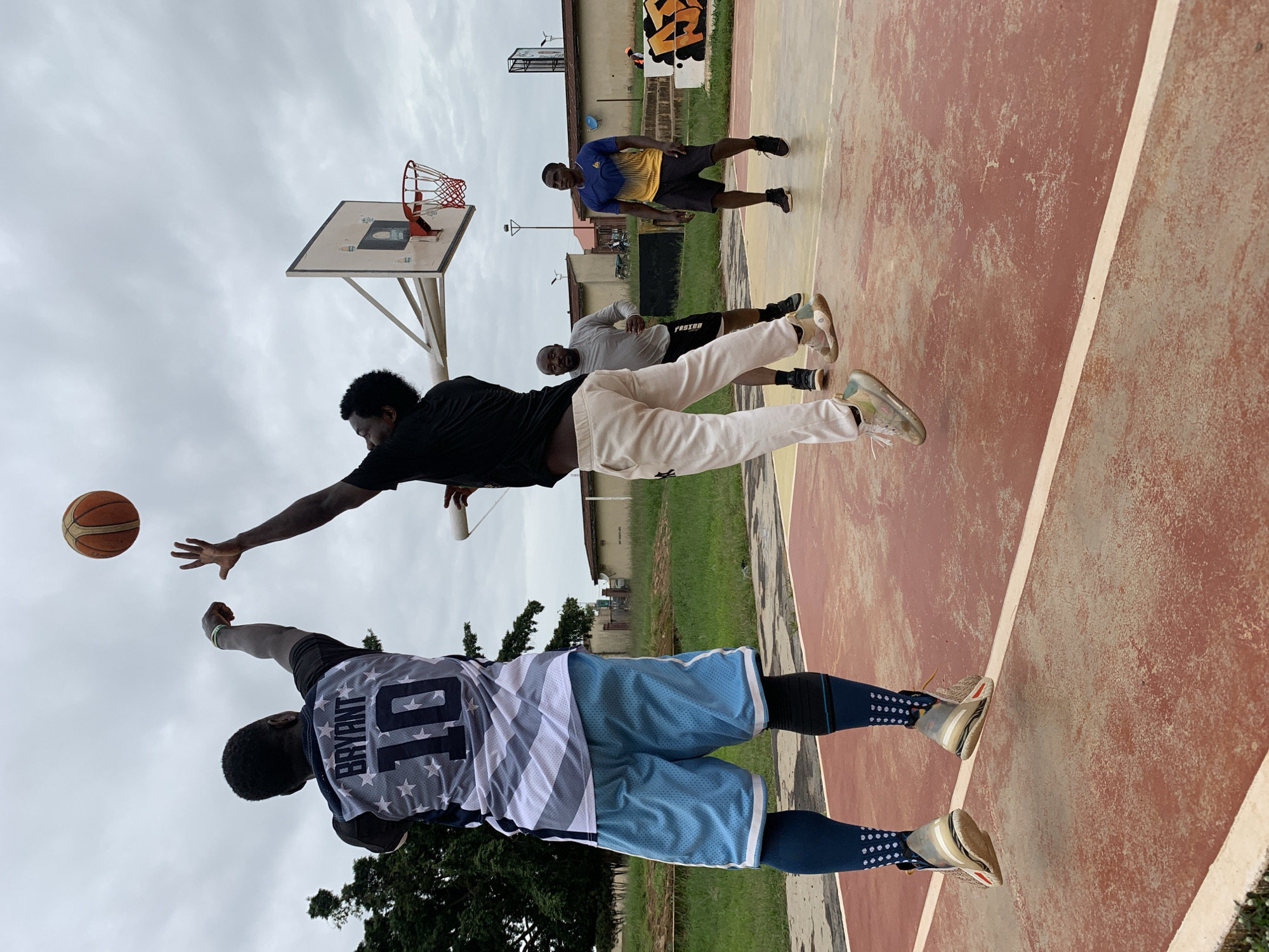 Outdoor basketball game on a red court in Jos, Nigeria