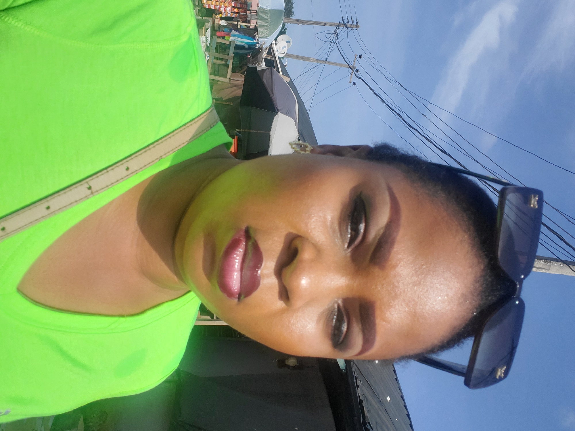 Woman takes selfies in bright sunlight in Lagos