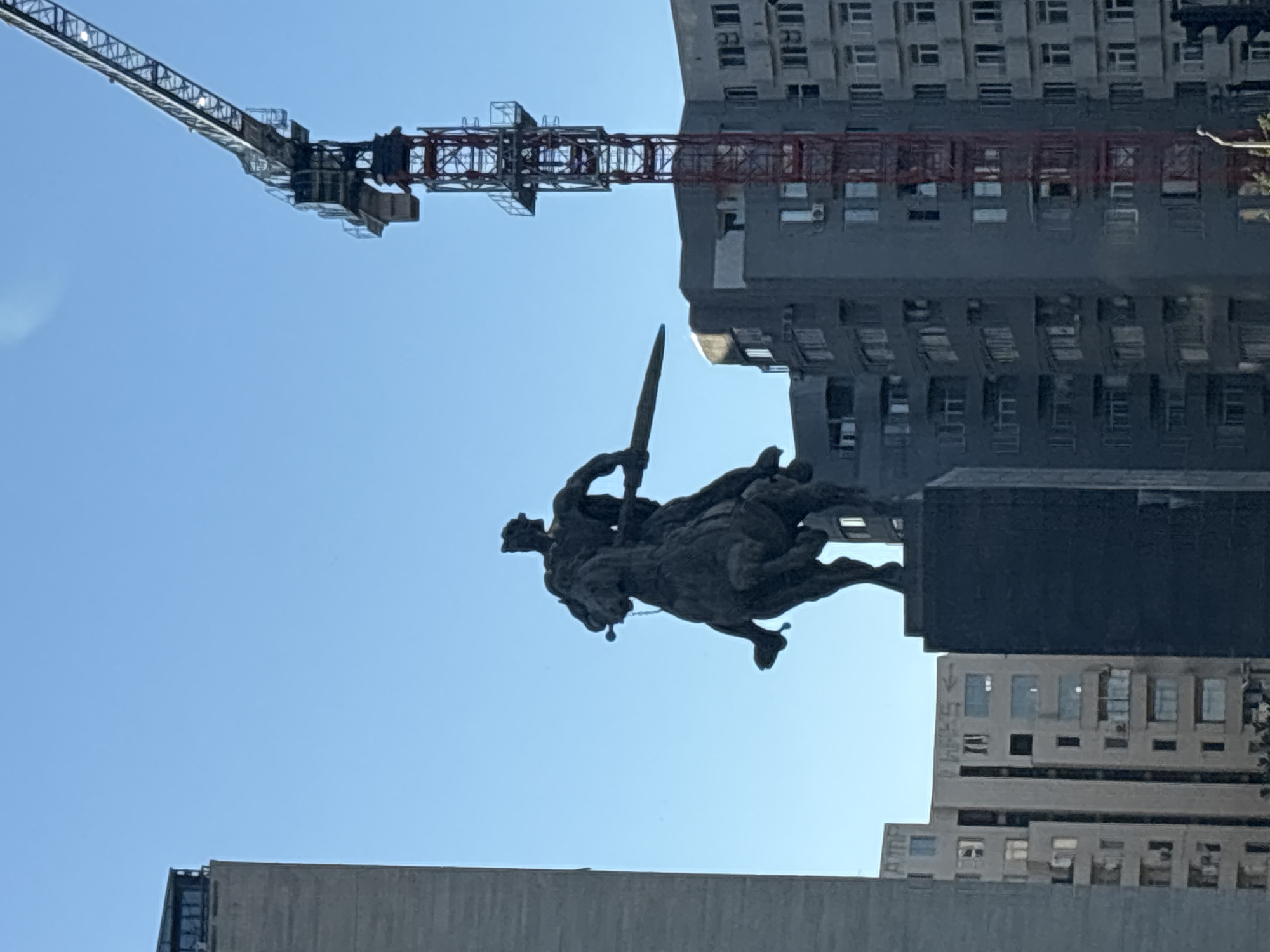 Warrior statue observed in busy Tbilisi street scene
