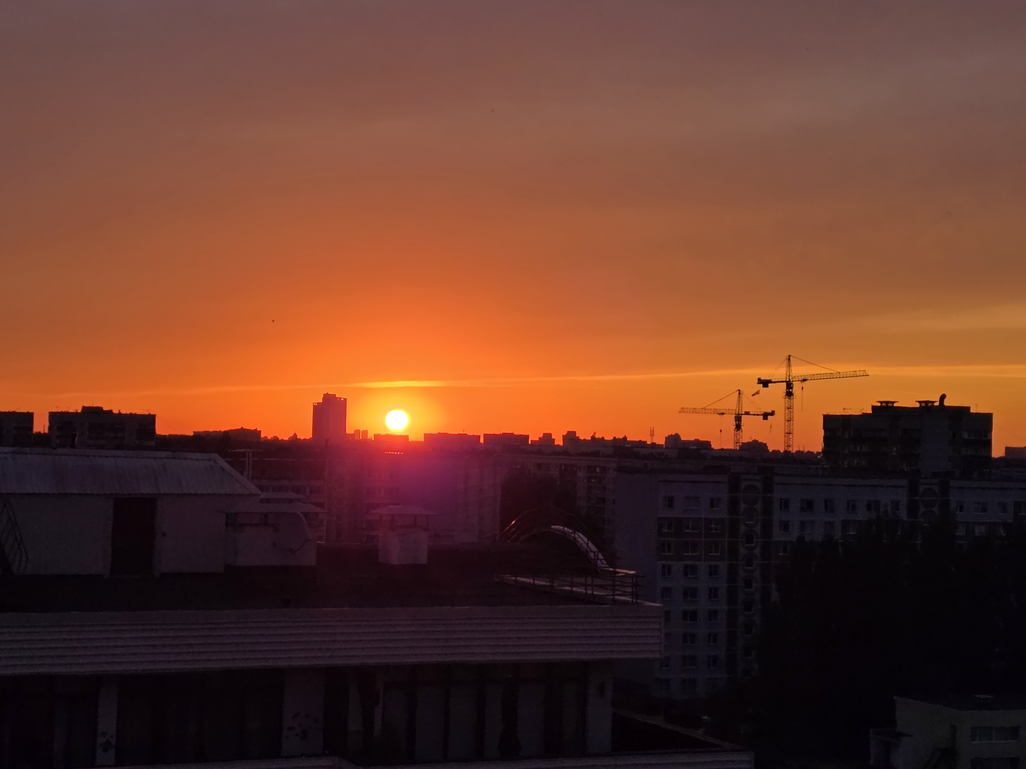 Riga skyline glows at sunset behind Soviet-era apartment blocks