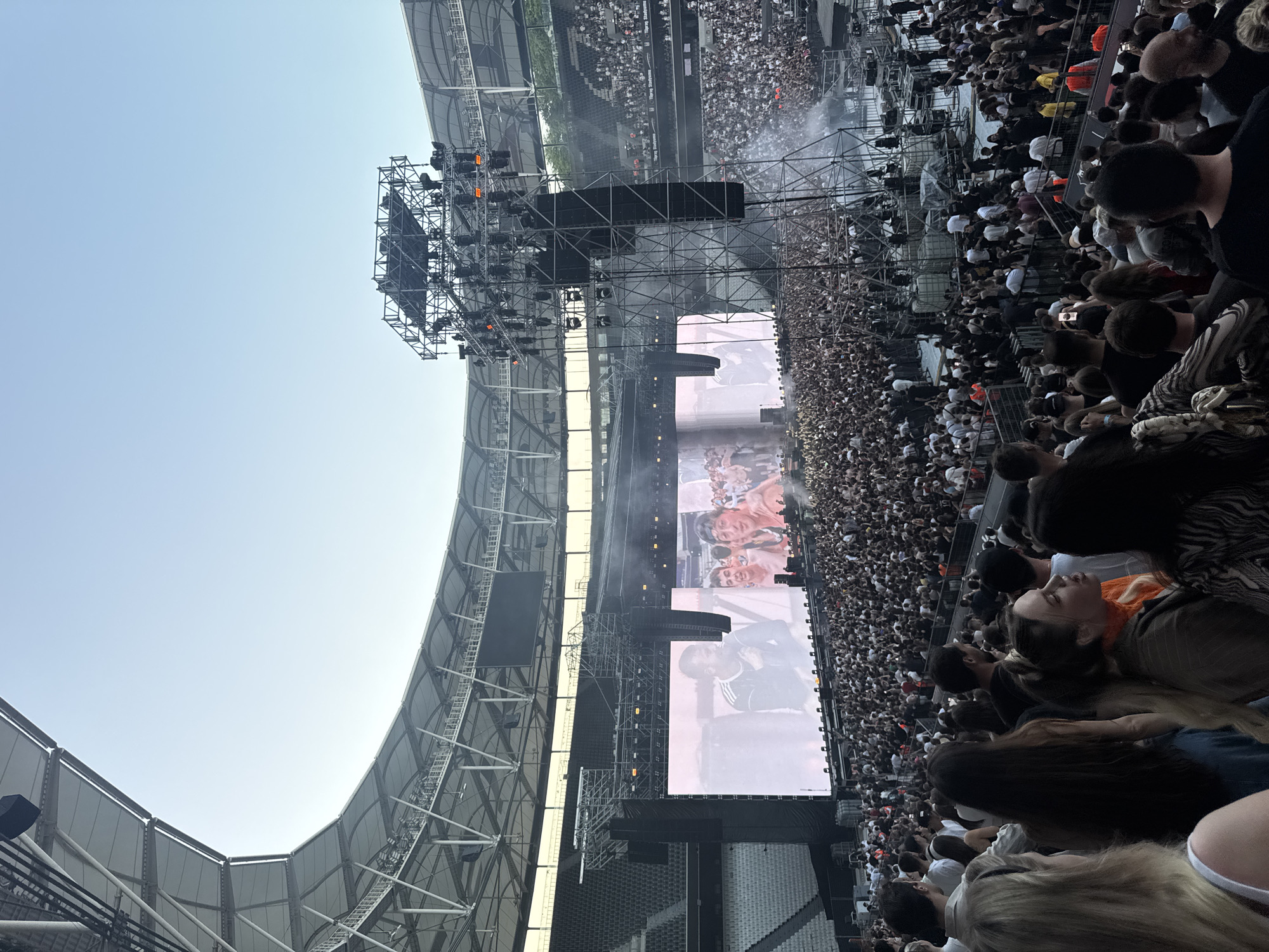 Outdoor concert observed at modern stadium under clear skies