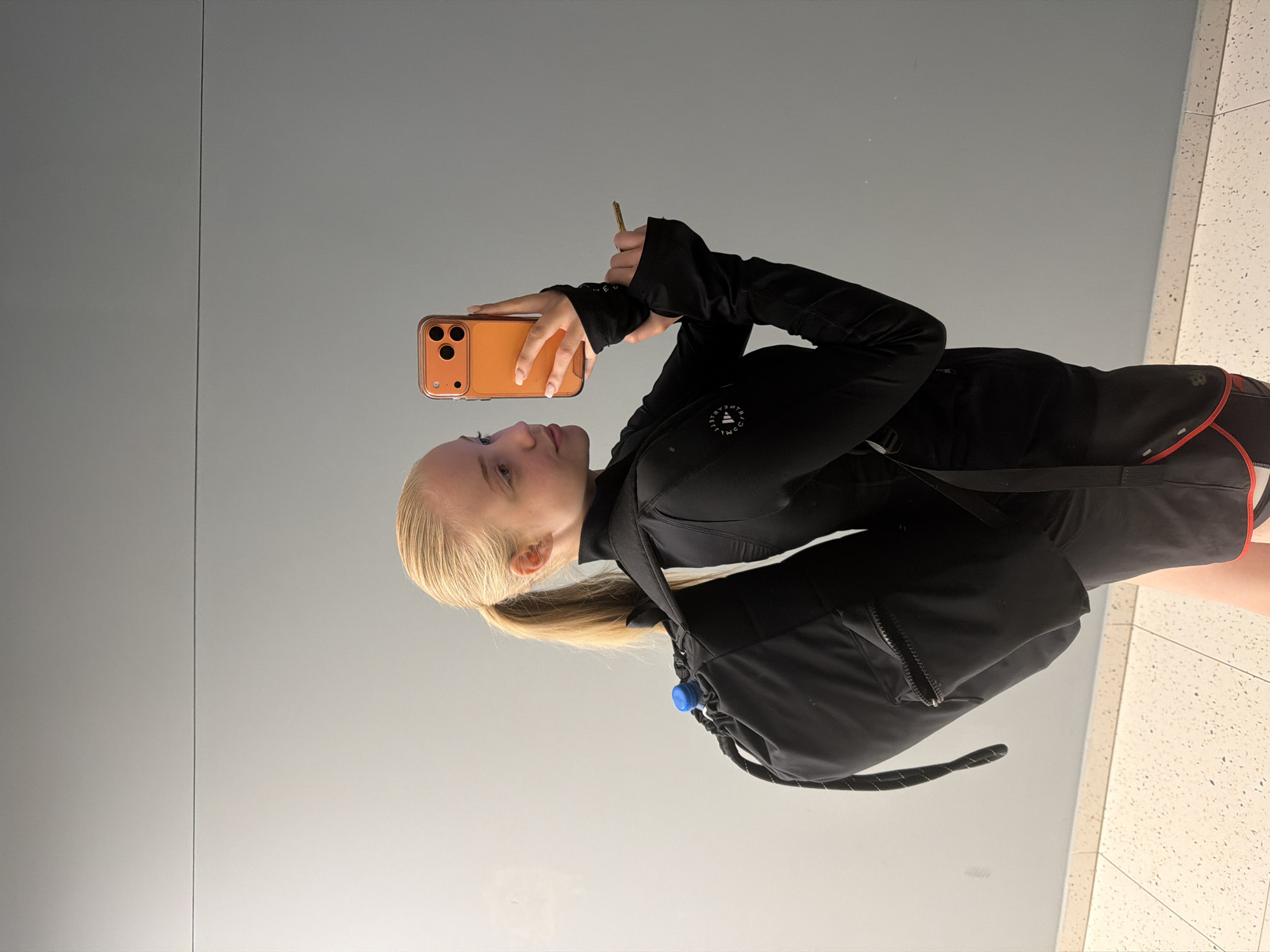 Person takes mirror selfie in athletic wear