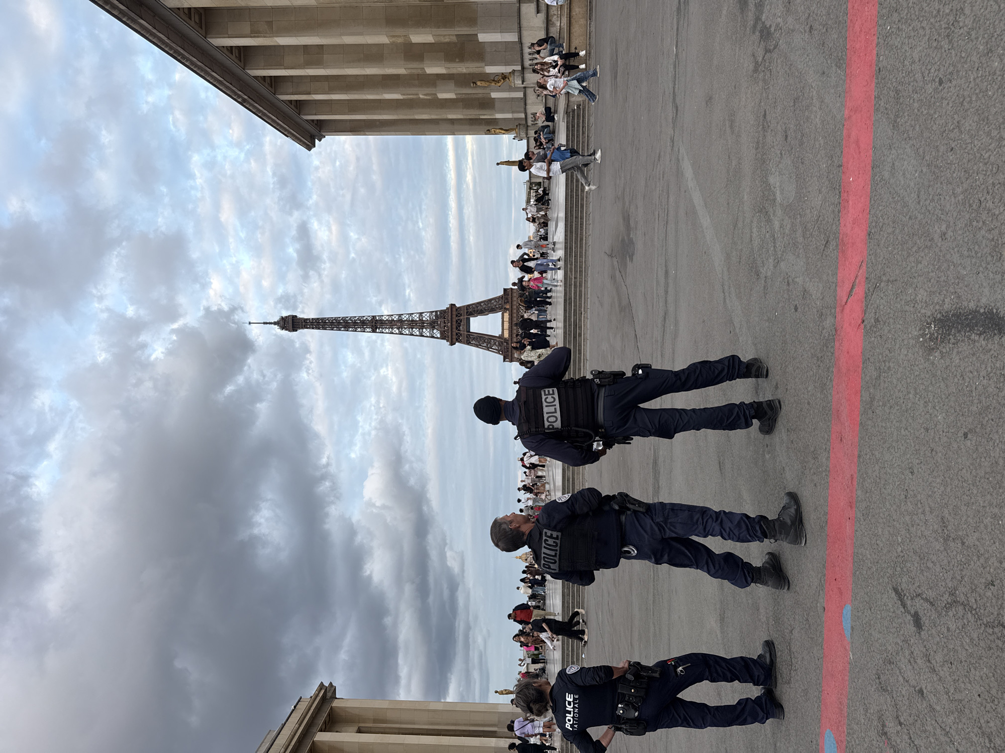 Evening crowds and police patrol near Eiffel Tower
