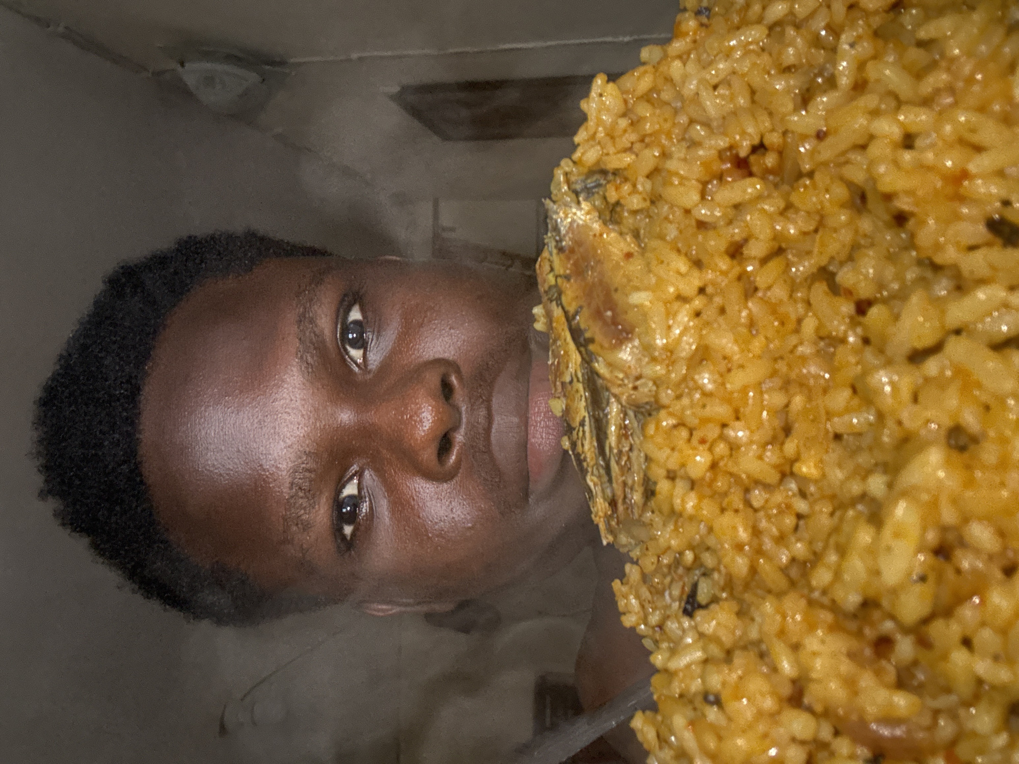 Young man cooks jollof rice, plays with mirror reflection
