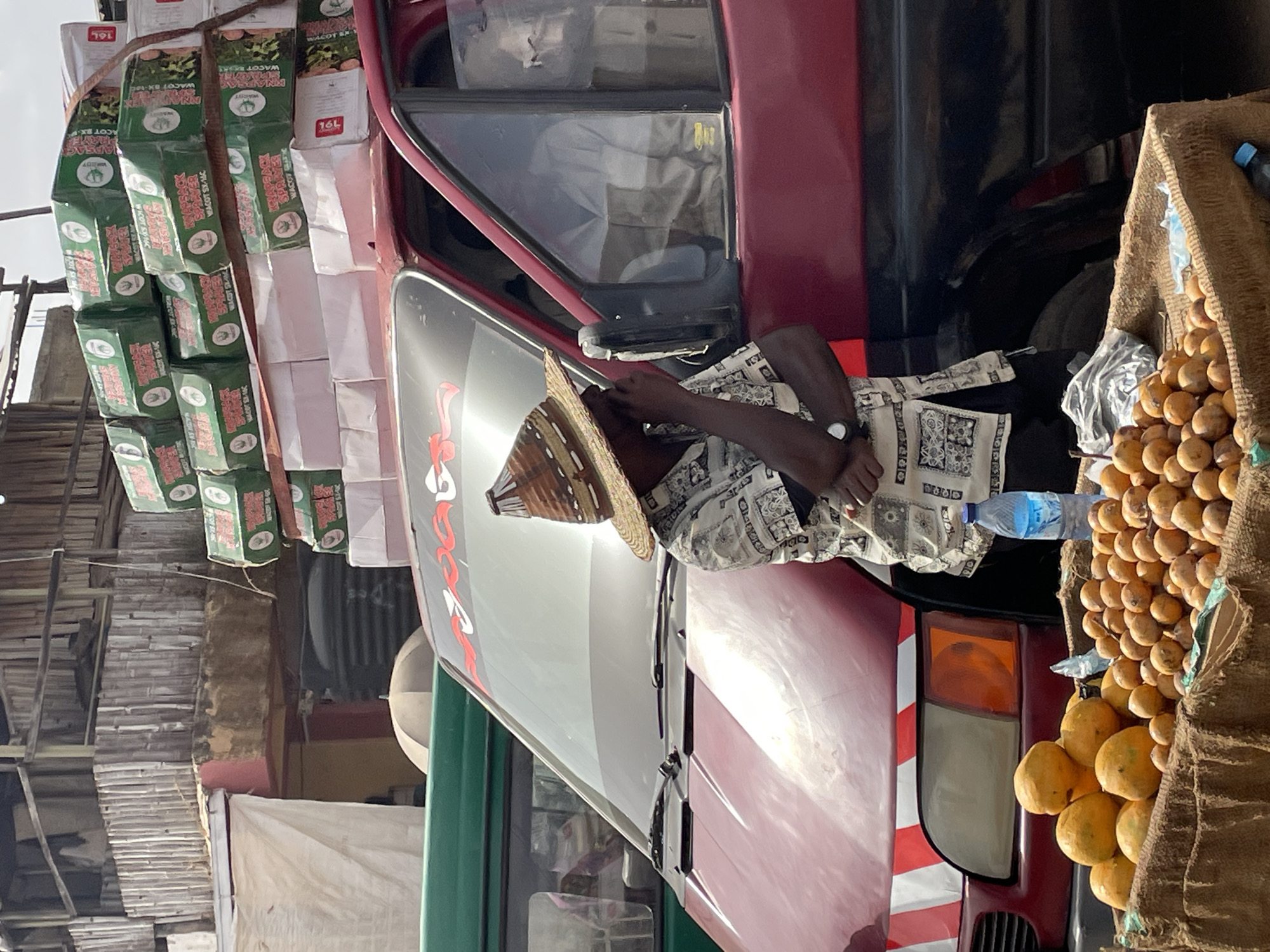 Person in straw hat observed near vehicle at market