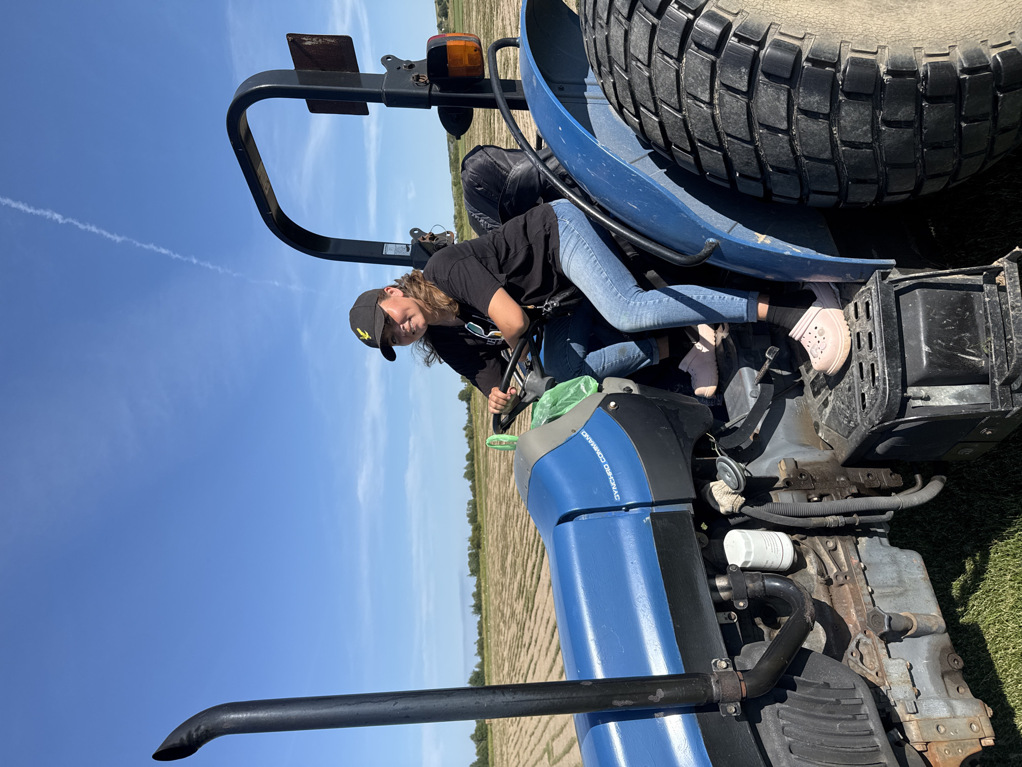 Behind the wheel of a blue tractor in rural Russia