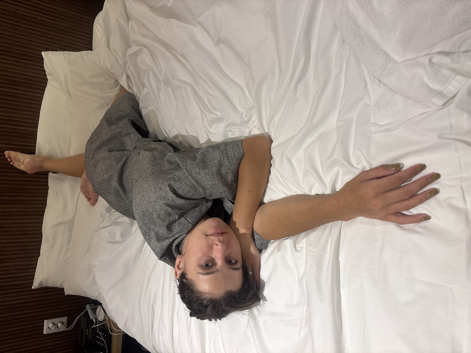 Relaxing on a white bed in a grey robe, Incheon