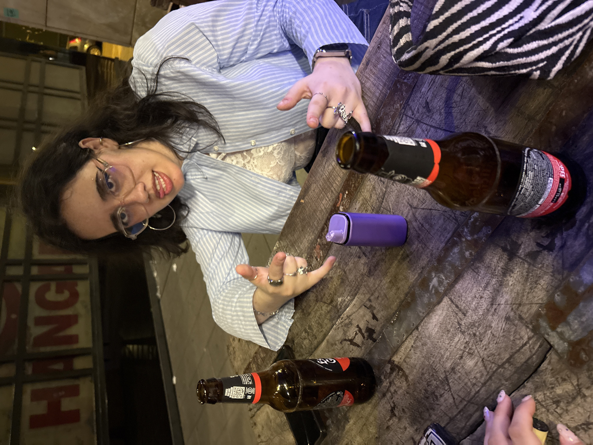 Woman makes rock gesture at Córdoba bar evening scene