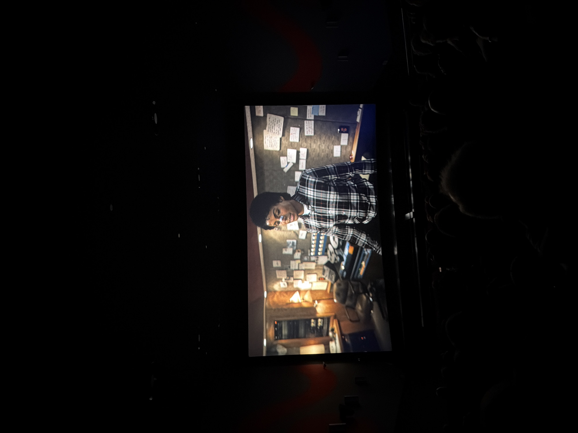 Rotated cinema screen displays film in darkened room