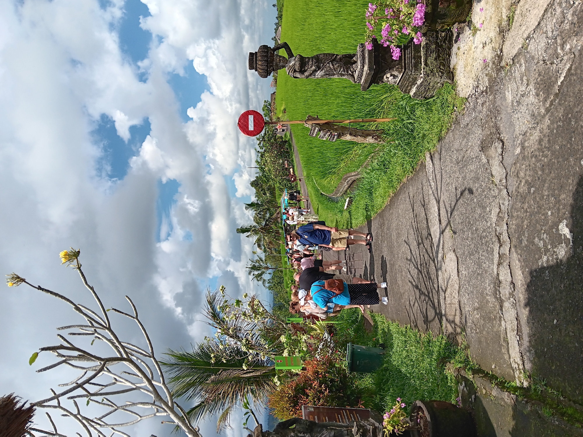 Tourists explore Penebel rice terraces under cloudy Indonesian skies