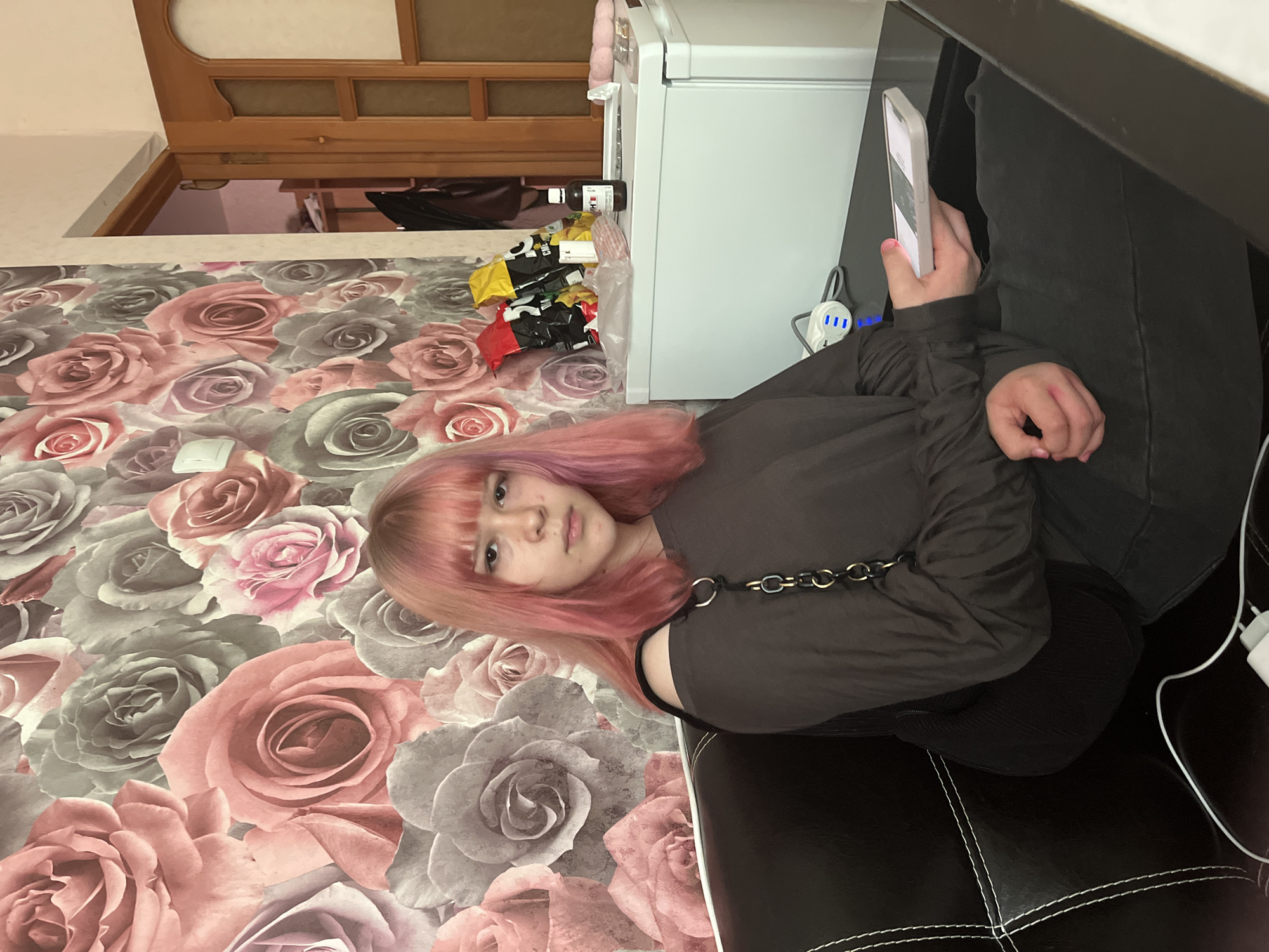 Pink-haired youth rests on sofa in Semyonov home
