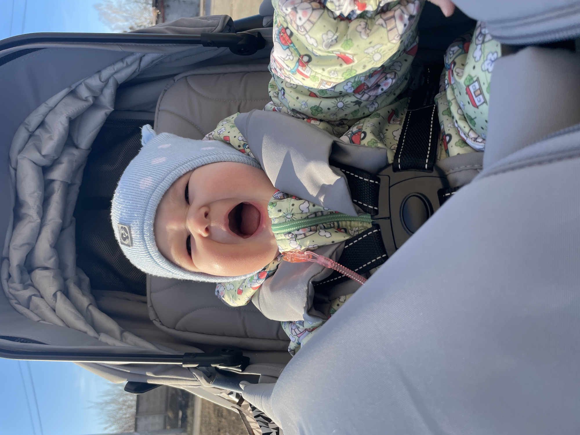 Baby in stroller vocalizes during outdoor outing in Russia