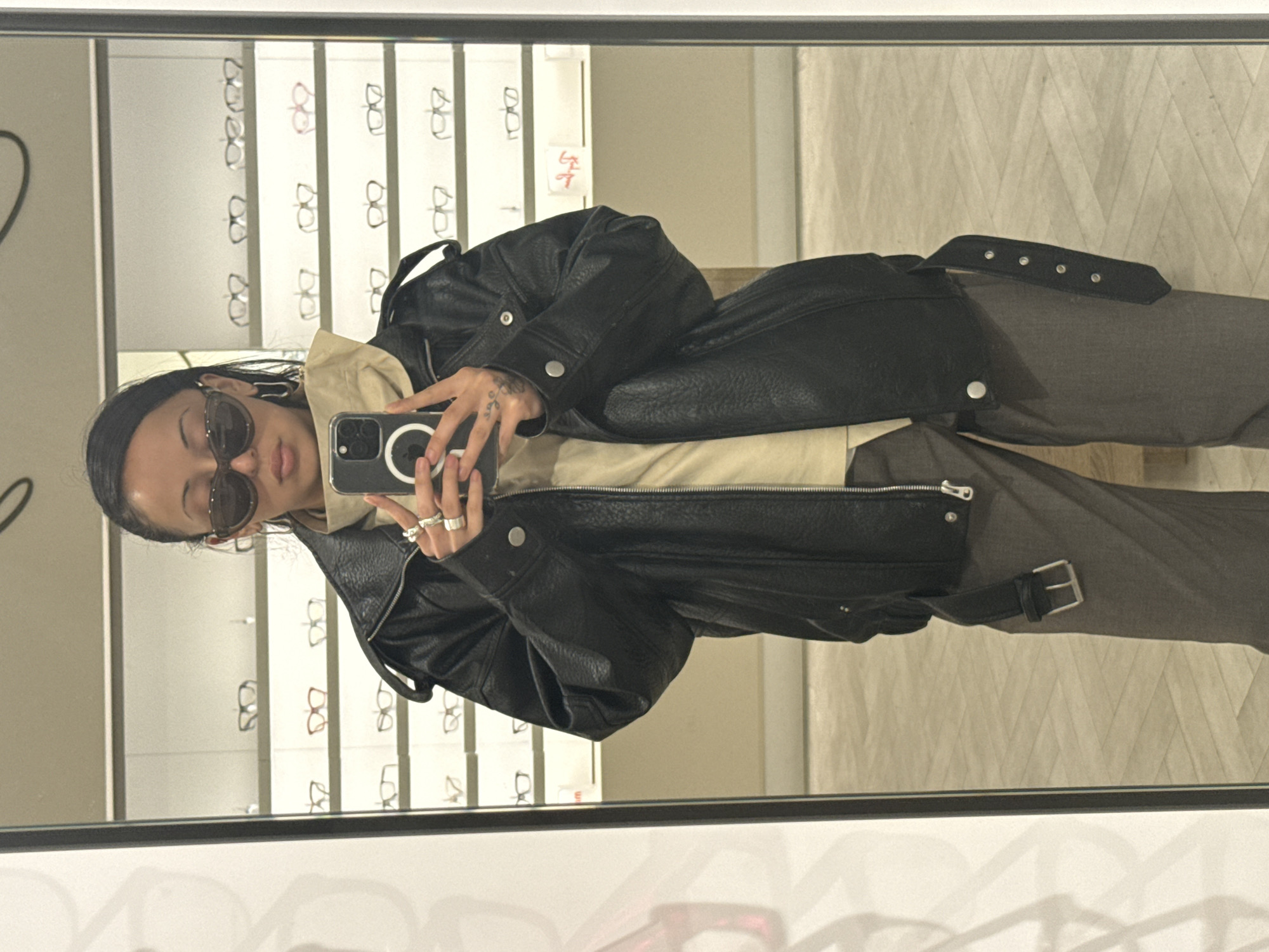 Person takes mirror selfie in London eyewear store