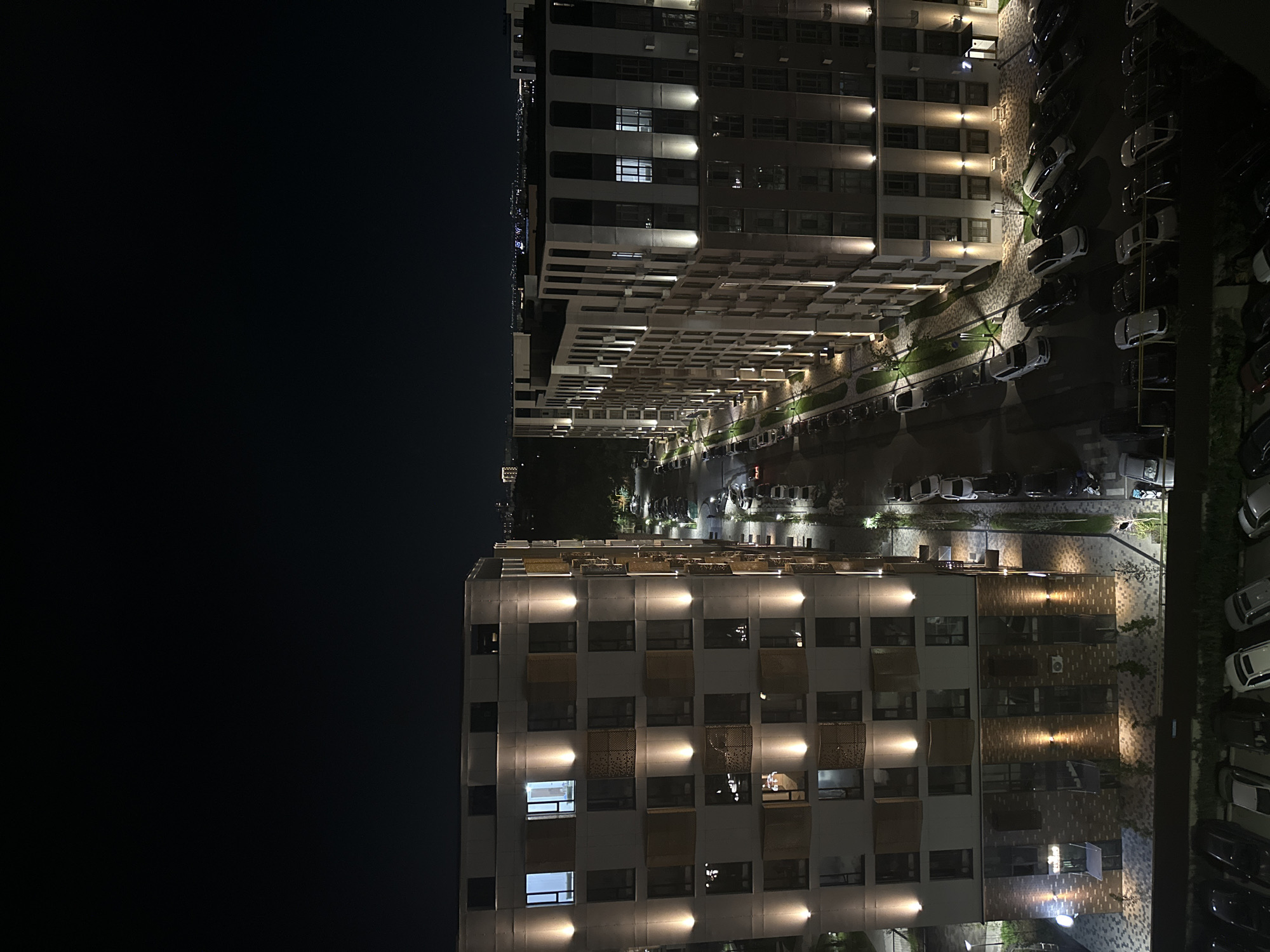 Nighttime street scene outside a modern residential complex