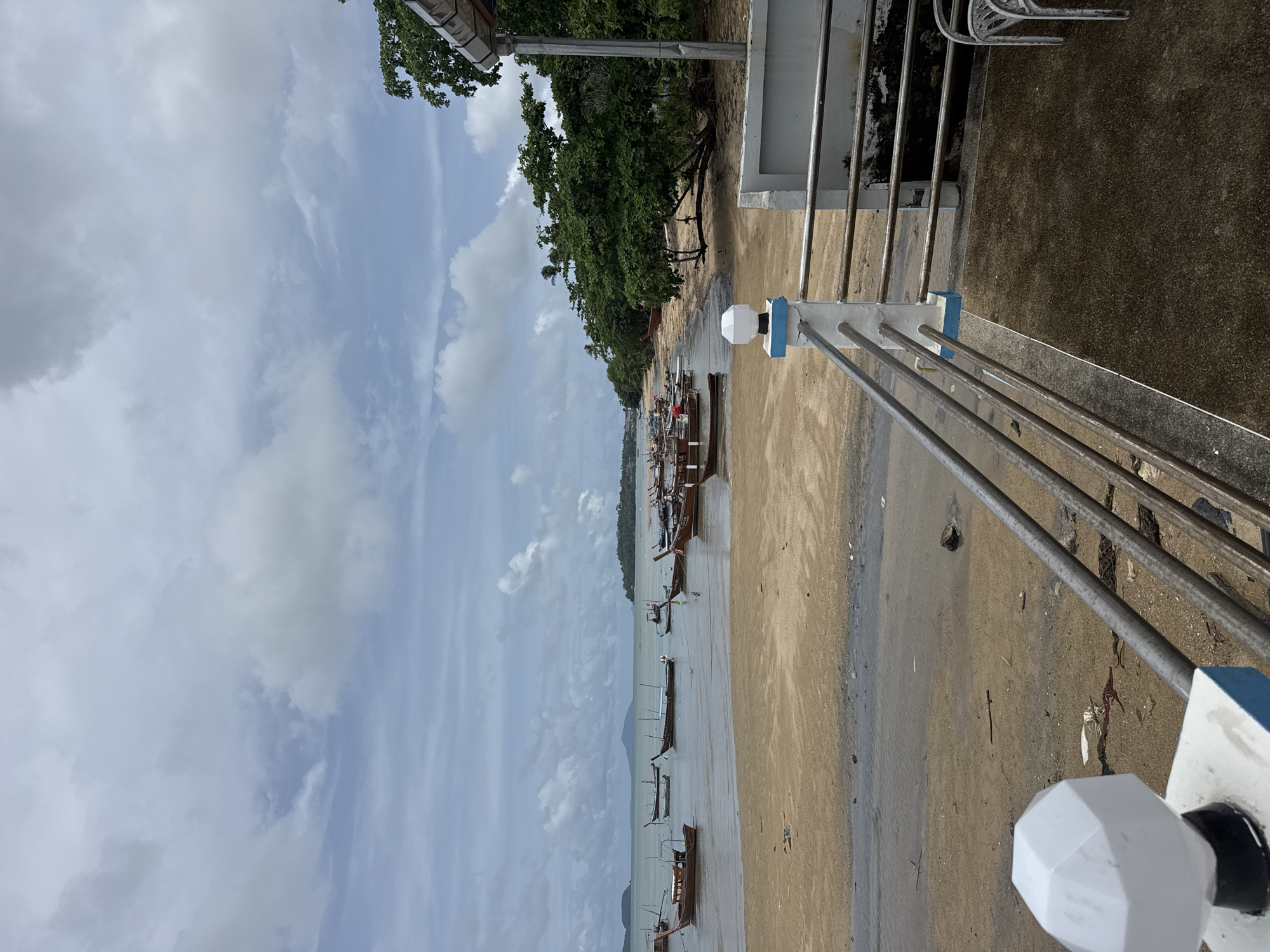 Morning scenes from Rawai beach show boats, beachgoers, overcast skies