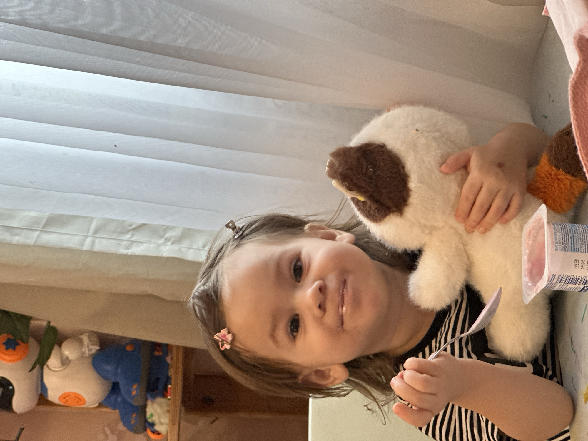 Toddler enjoys snack time with stuffed animals in Russia