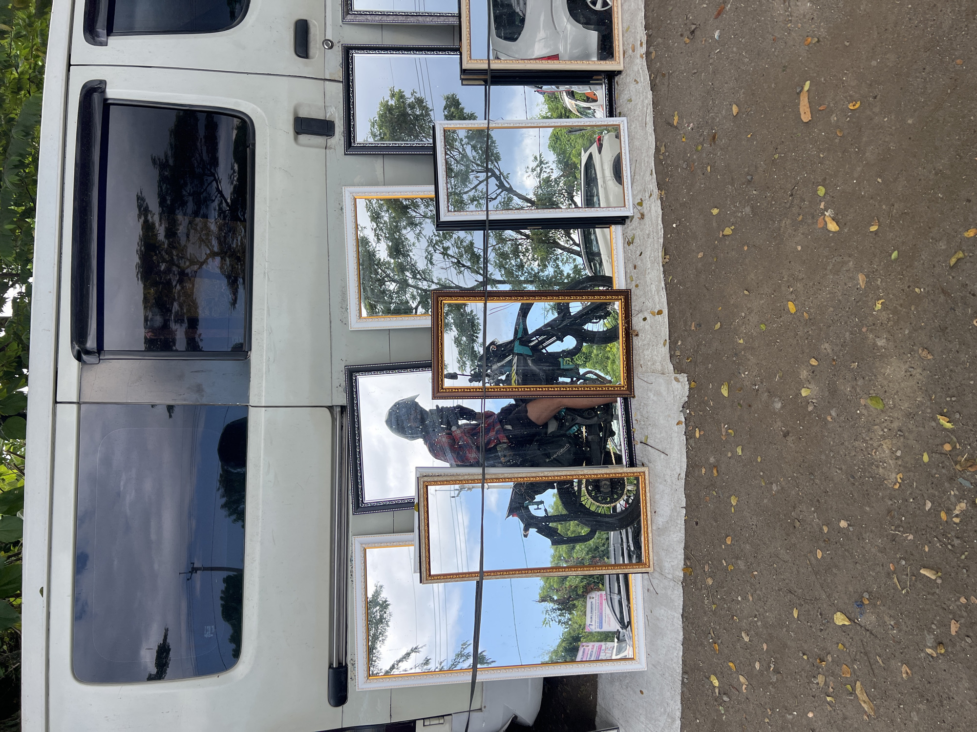 Street vendor displays mirrors, rabbits in cages in Gianyar
