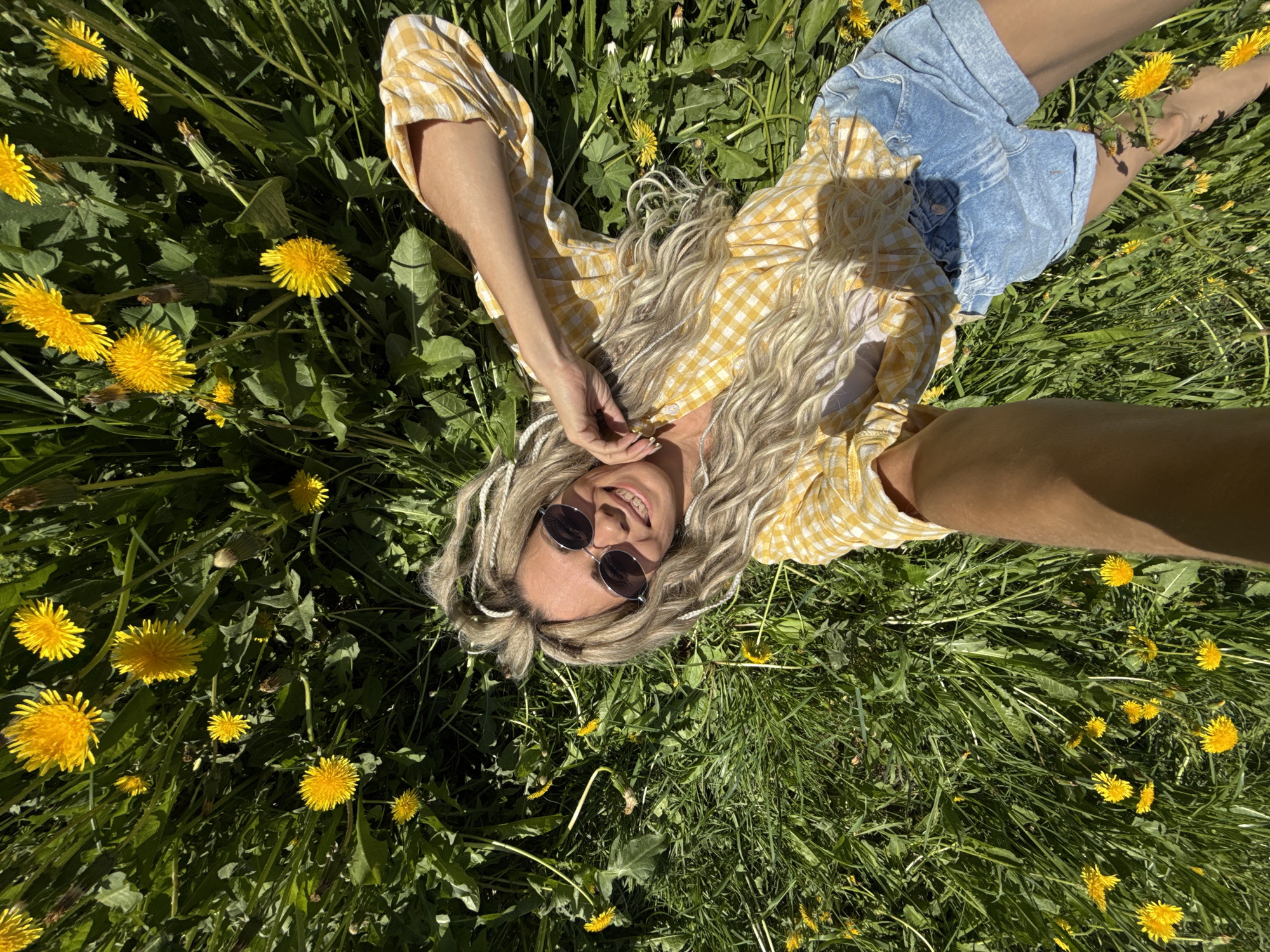 Woman takes selfies in dandelion field near Rusanovo