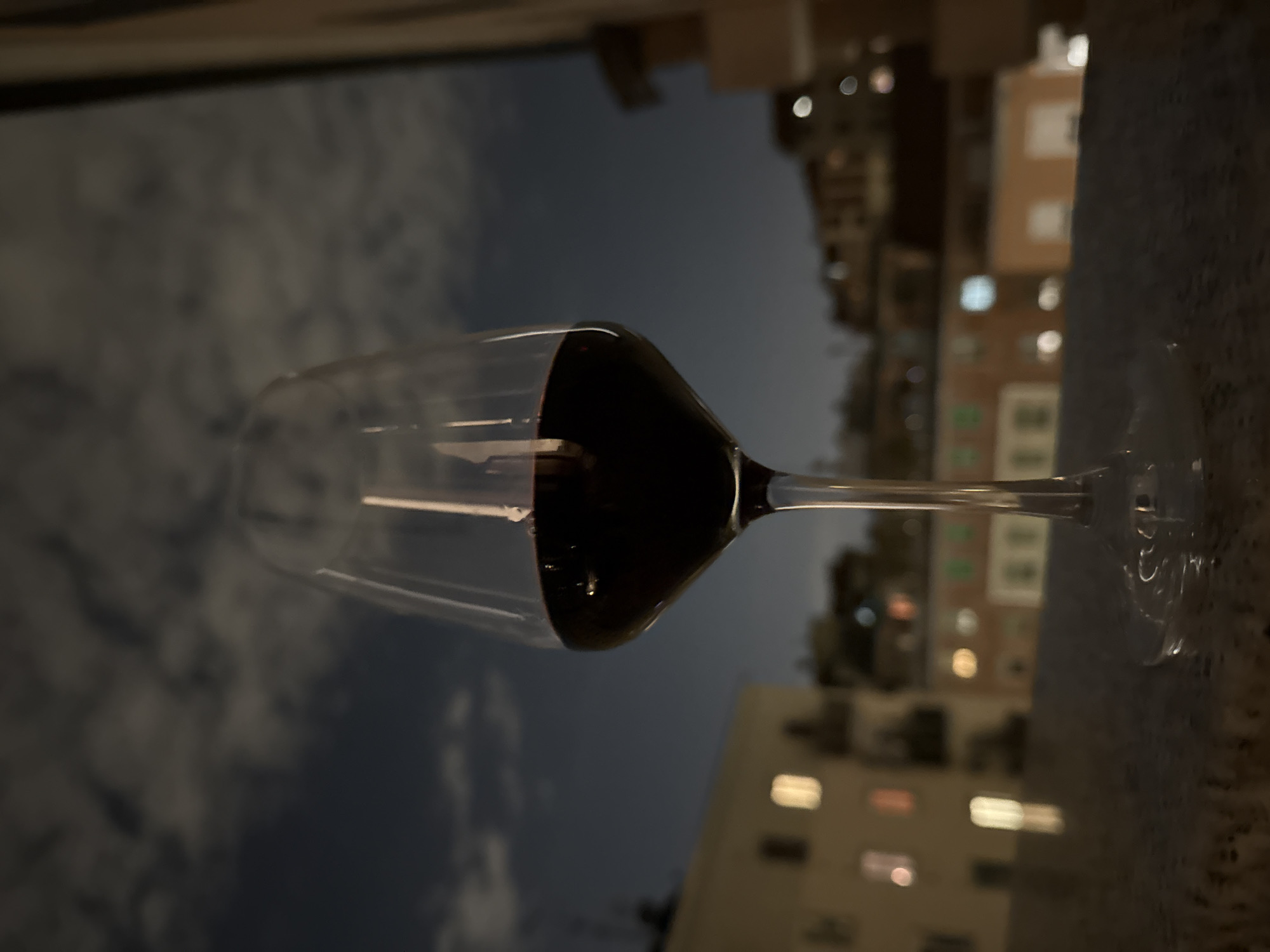 Evening wine moment captured overlooking Milan cityscape