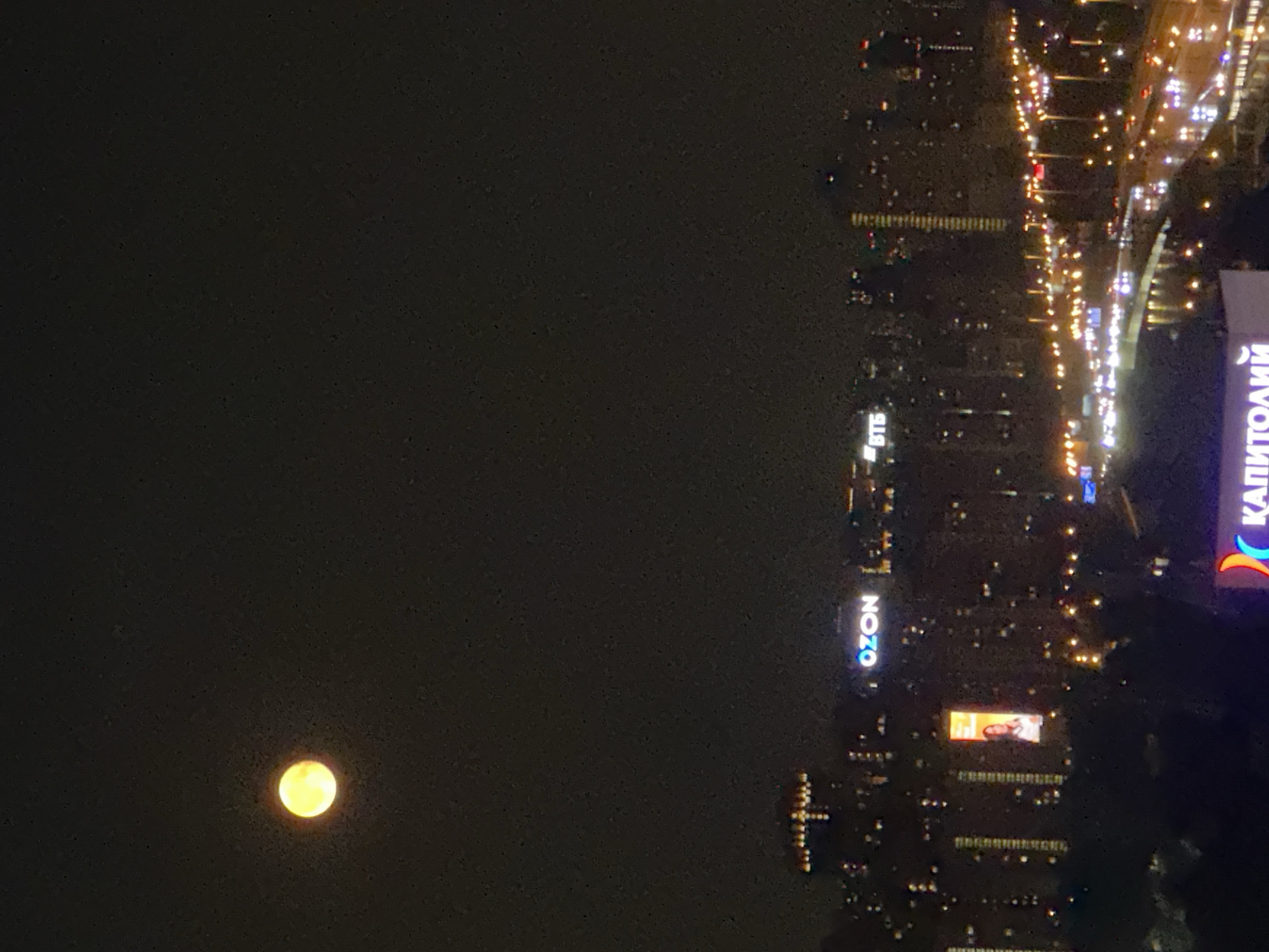 Full moon glows yellow over Khimki's lit-up urban sprawl