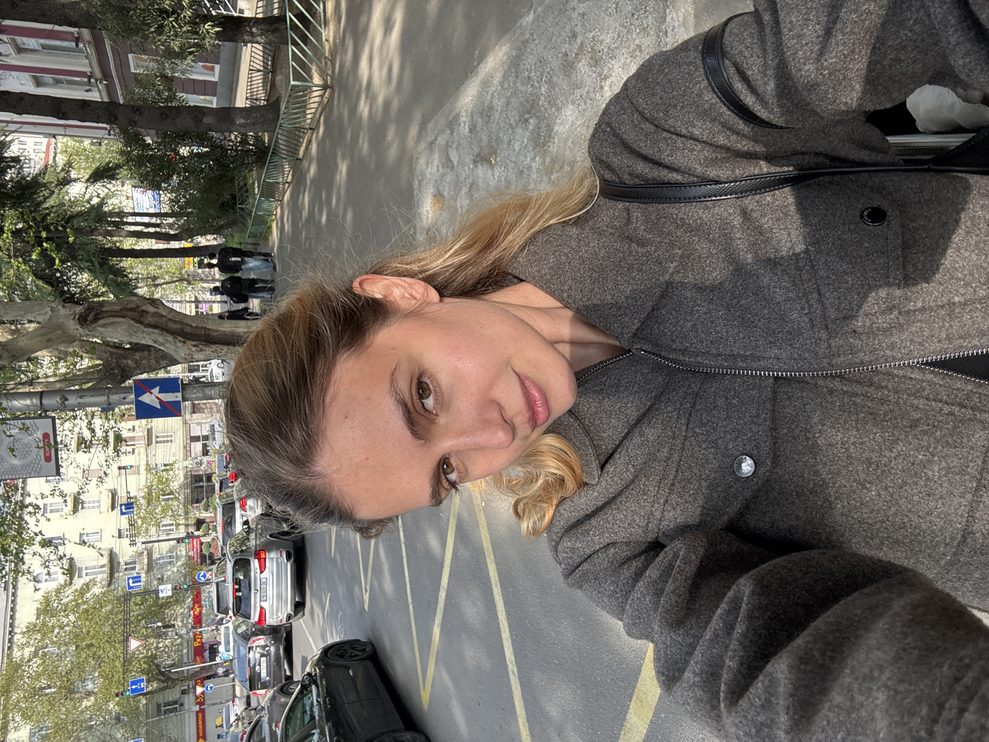 Woman takes selfie on busy urban street