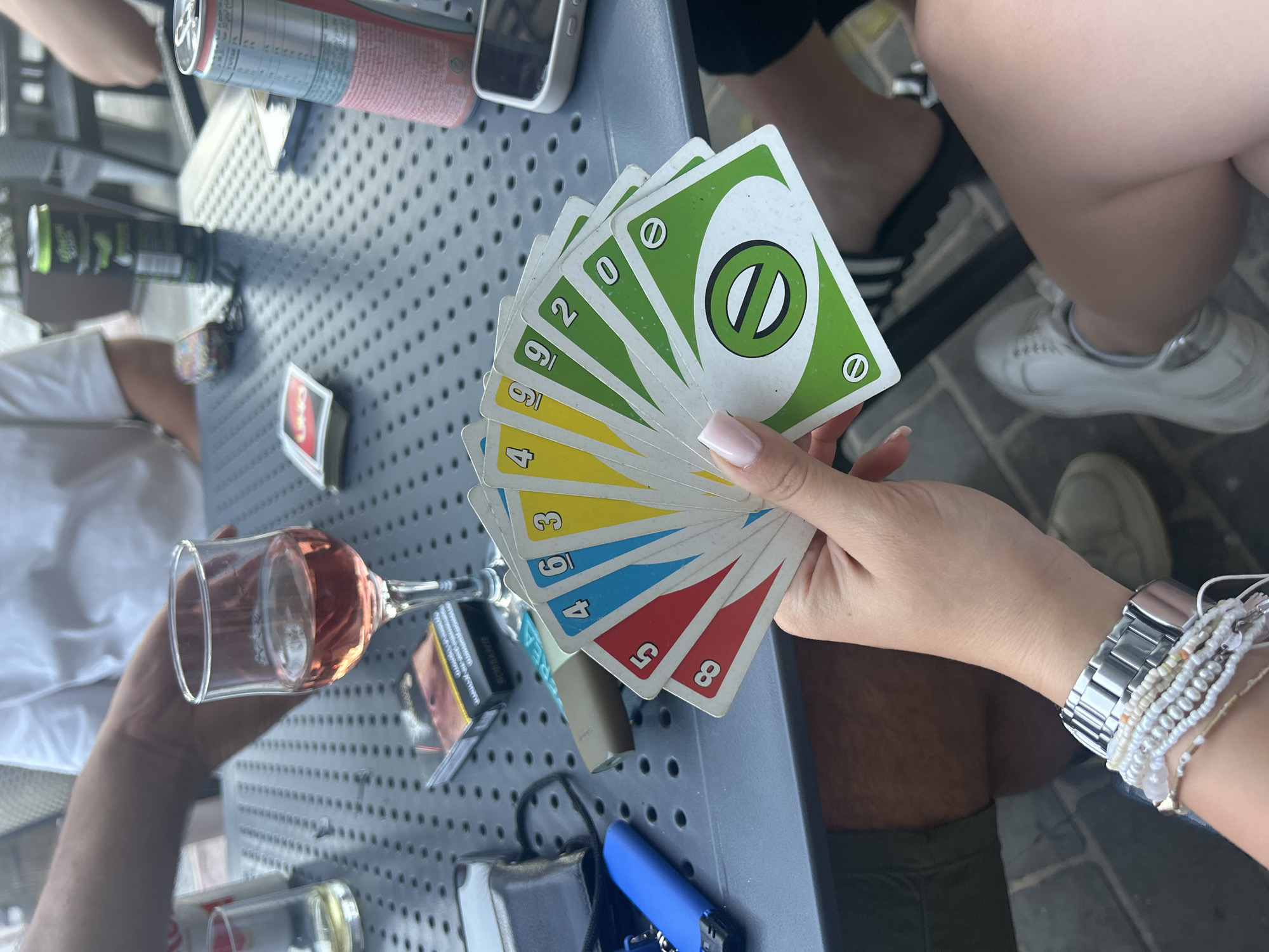 Friends play UNO cards at outdoor Malta café