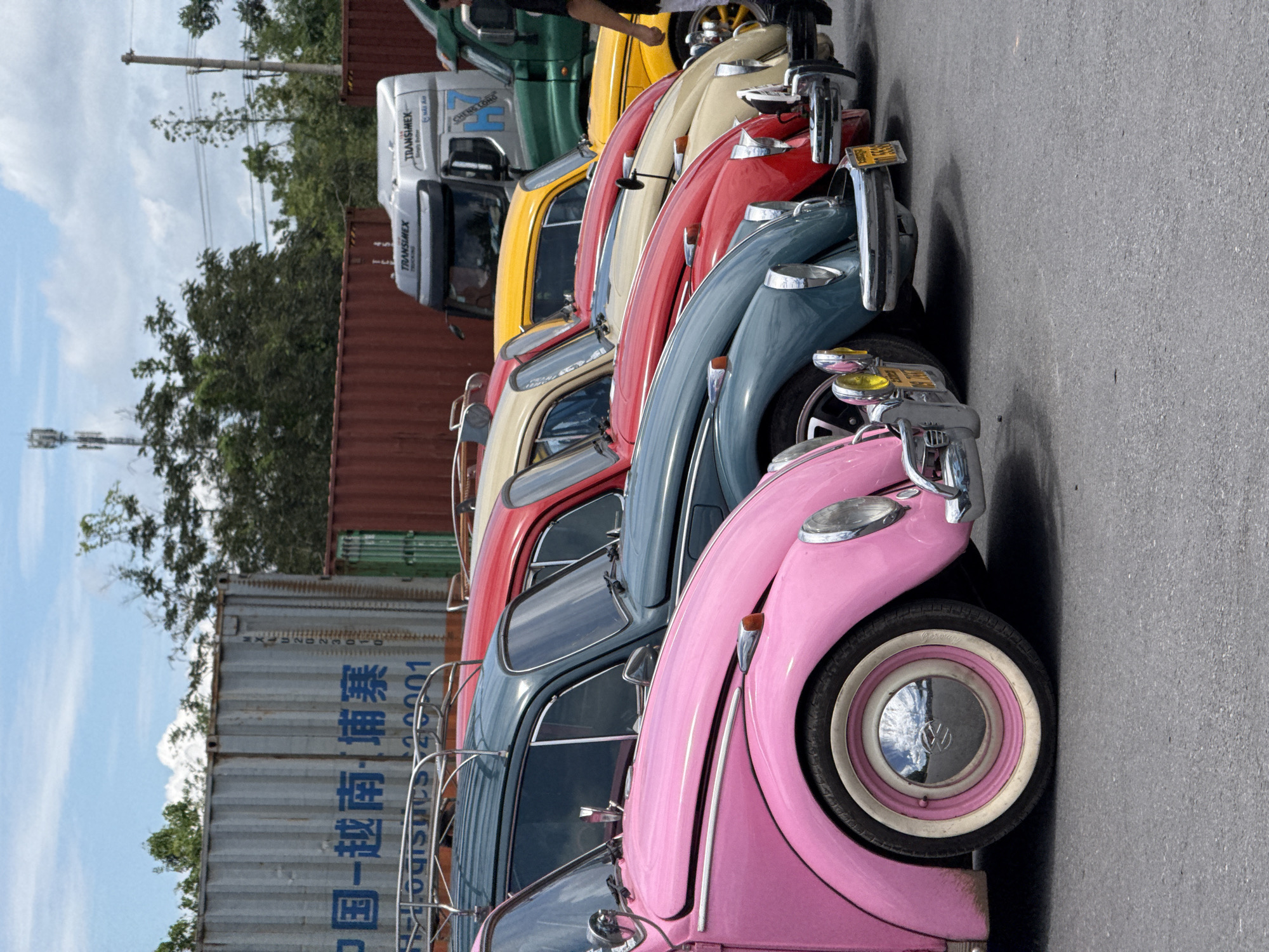 Rainbow row of vintage VW Beetles parked in Lao Bảo, Vietnam