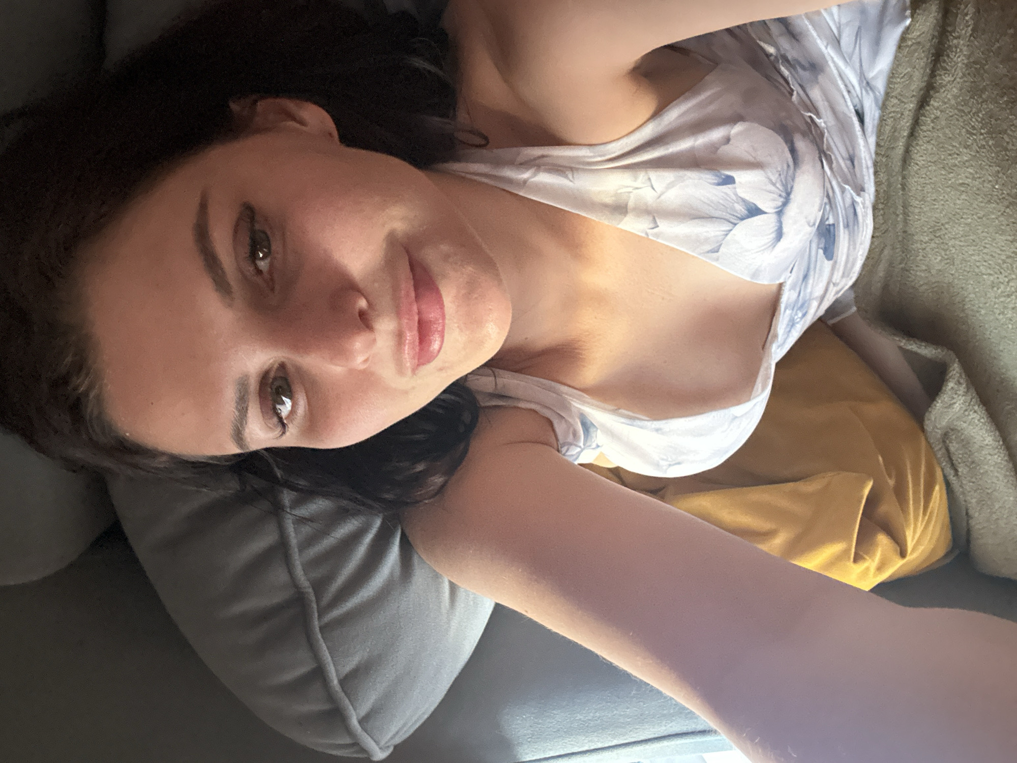 Relaxing at home on a blue sofa with a calico cat nearby