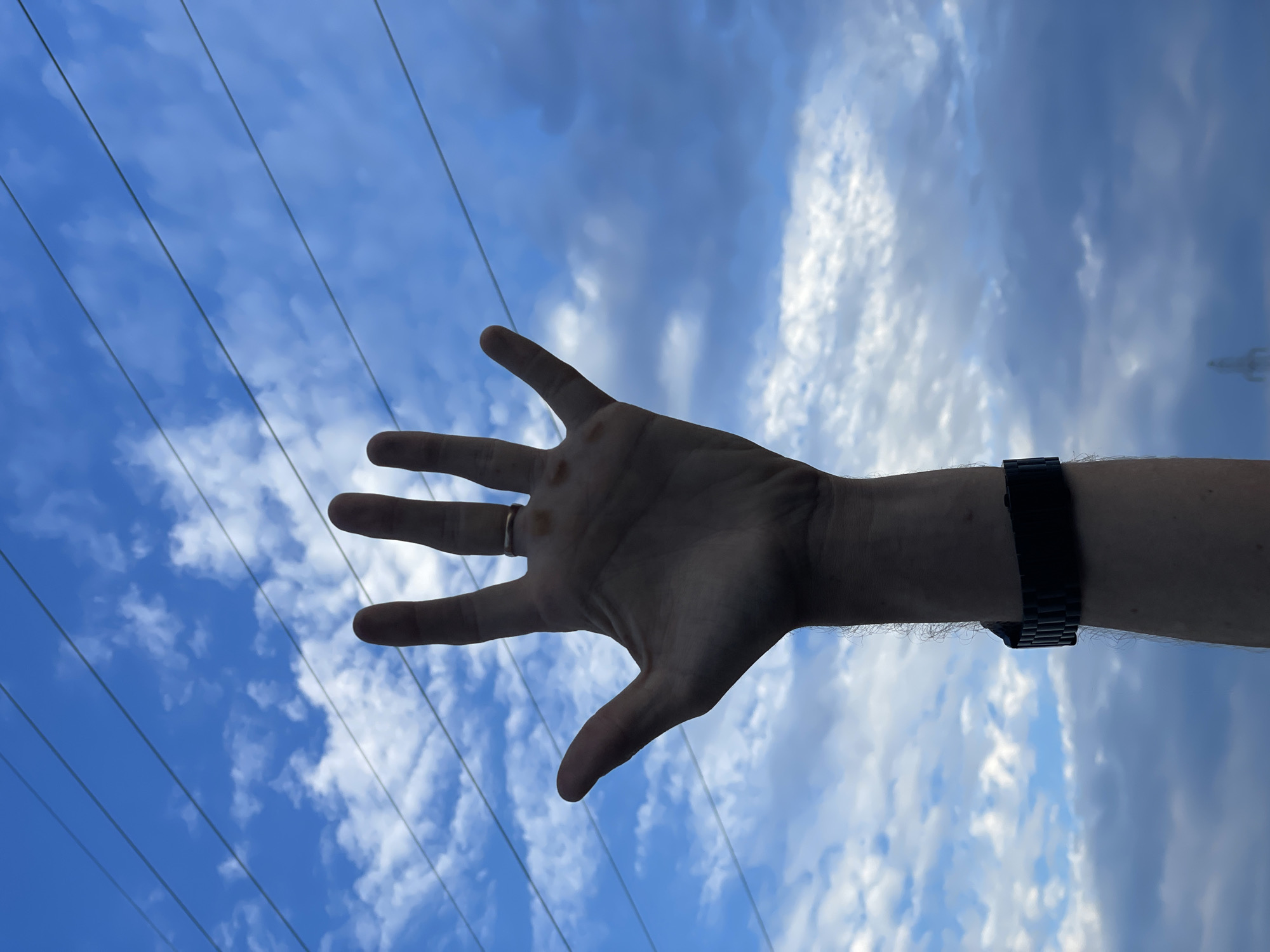 Hand raised to the sky in Aktau, ring and watch visible