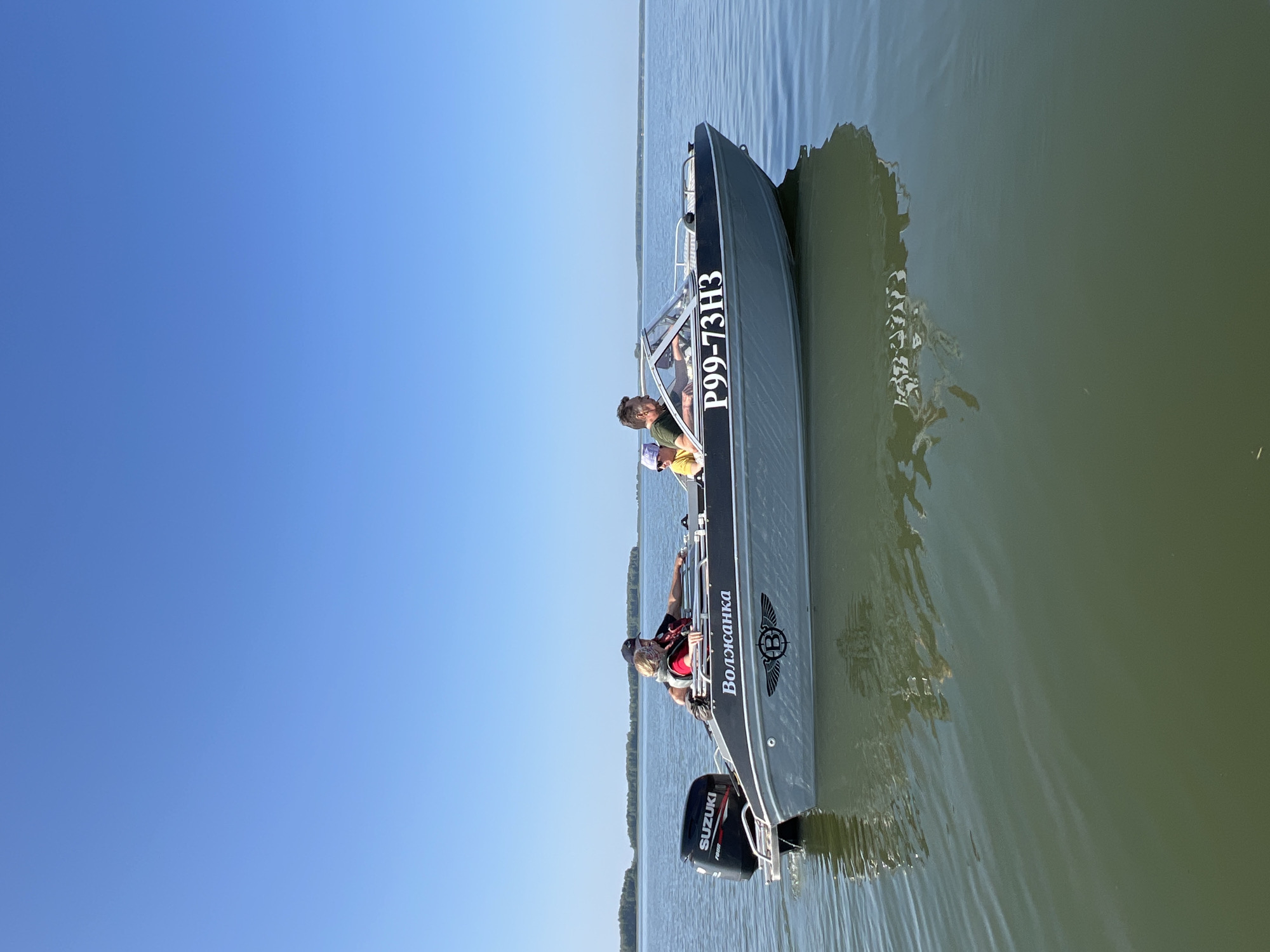 Fishing trip on a calm Russian lake aboard the Волжанка