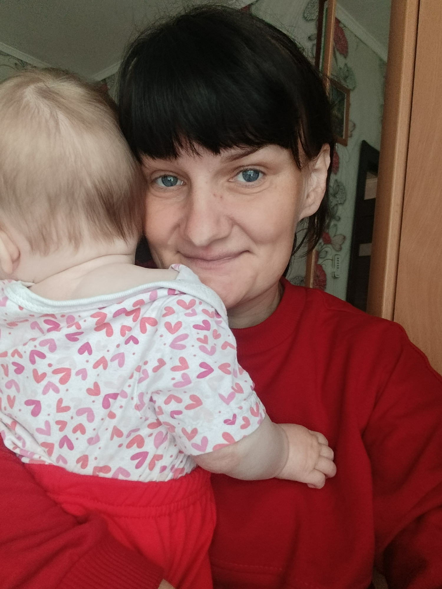 Woman holds baby in early morning moment, Foki Russia