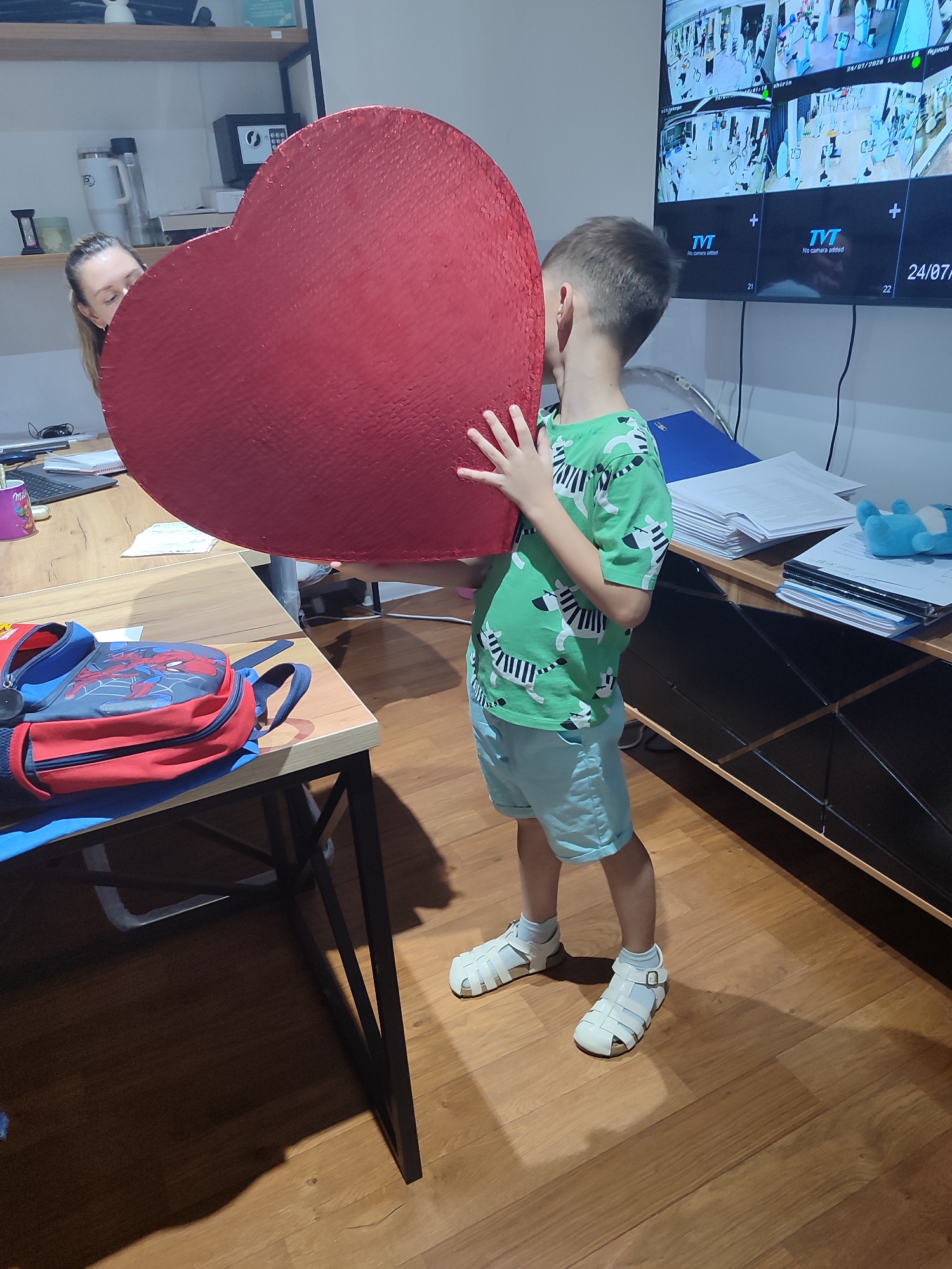 Holding a giant heart-shaped chalkboard in a Tashkent hallway