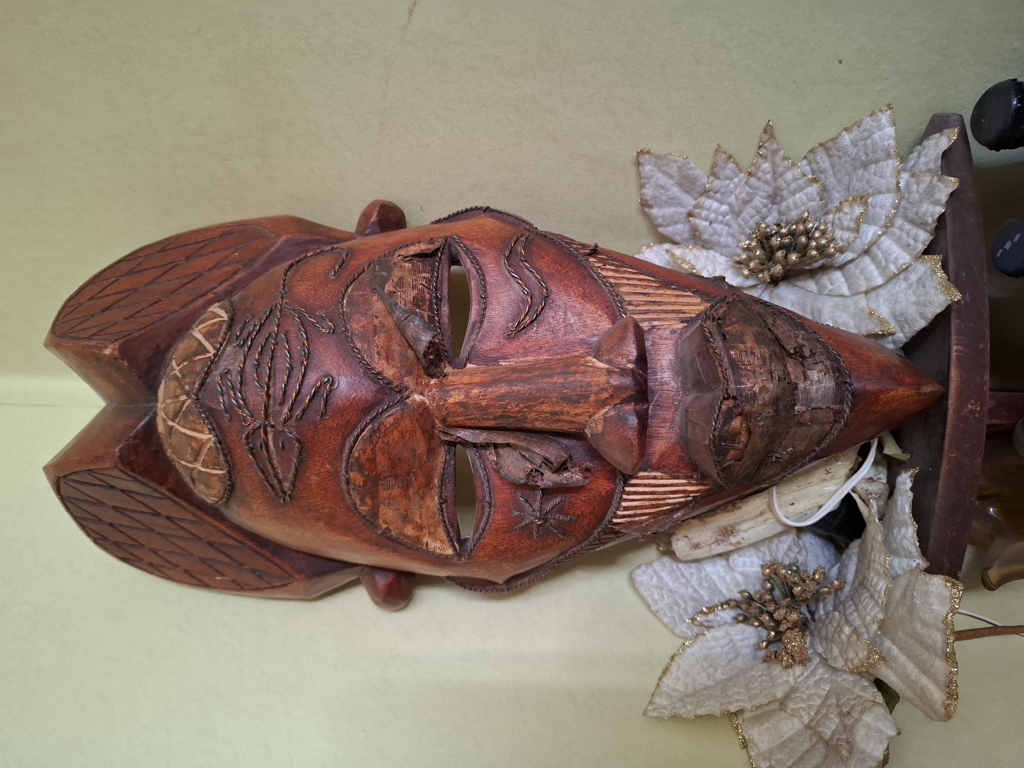 Wooden mask with artificial flowers observed in Sofia
