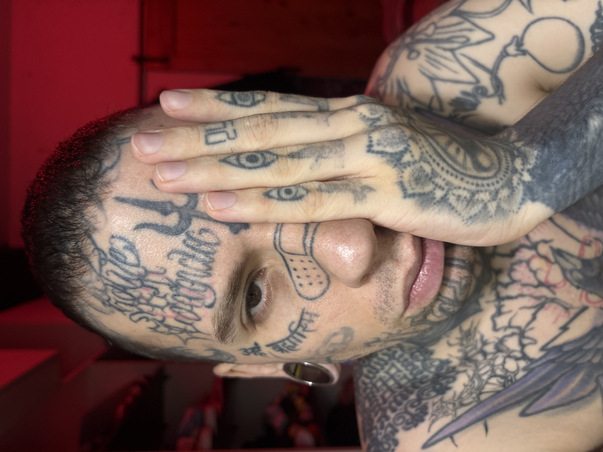 Tattooed man covers eye in Buenos Aires early morning