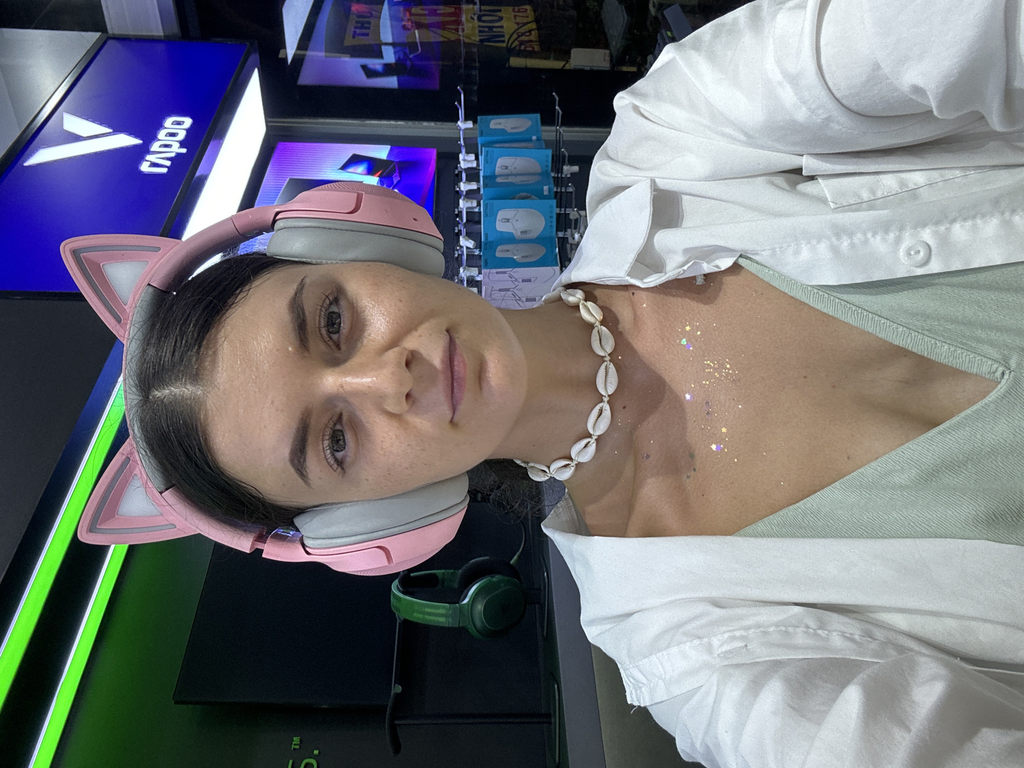 Woman in cat-ear headphones photographed indoors in Thuận An