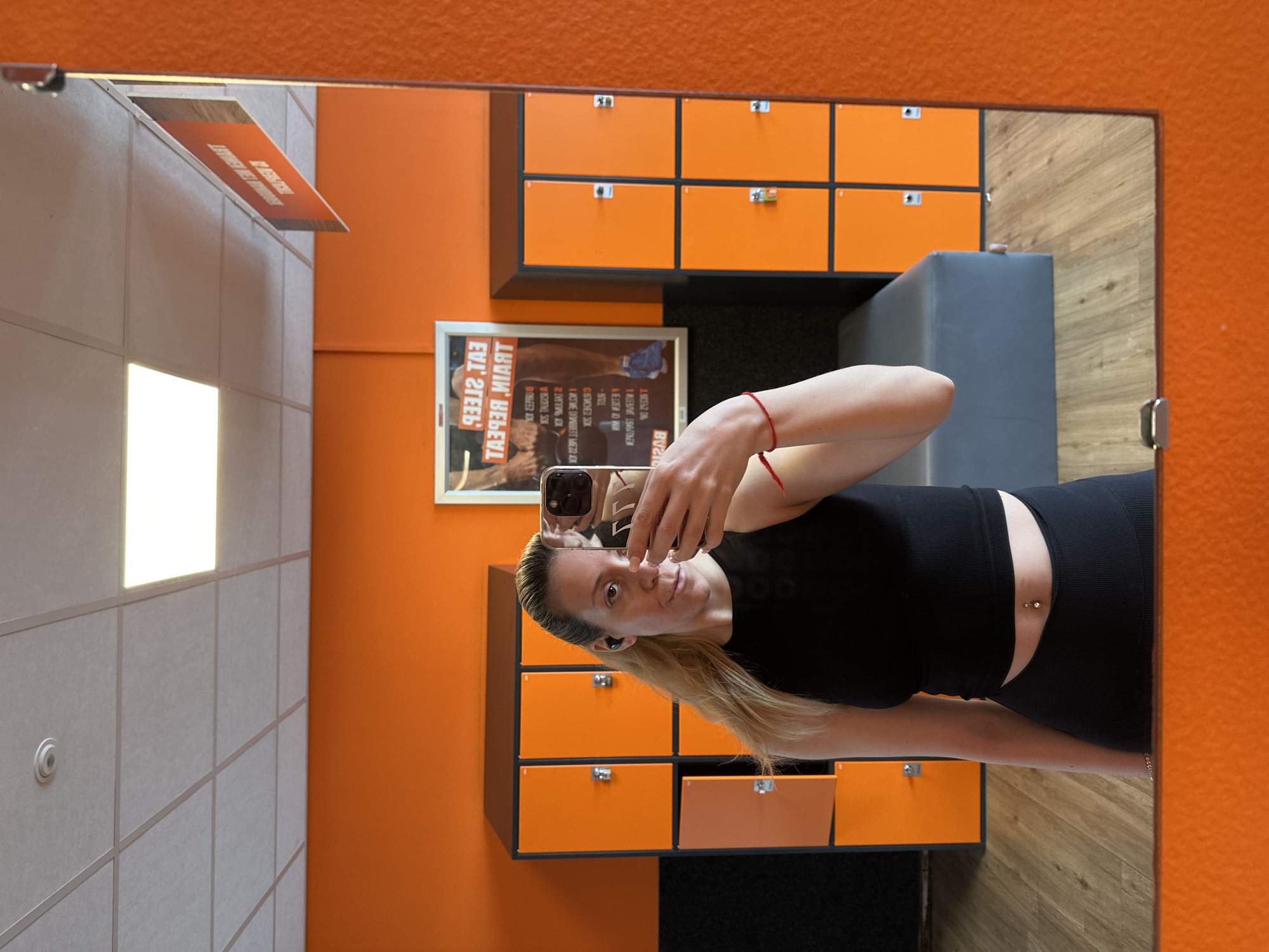 Woman takes mirror selfie in Amsterdam gym locker room