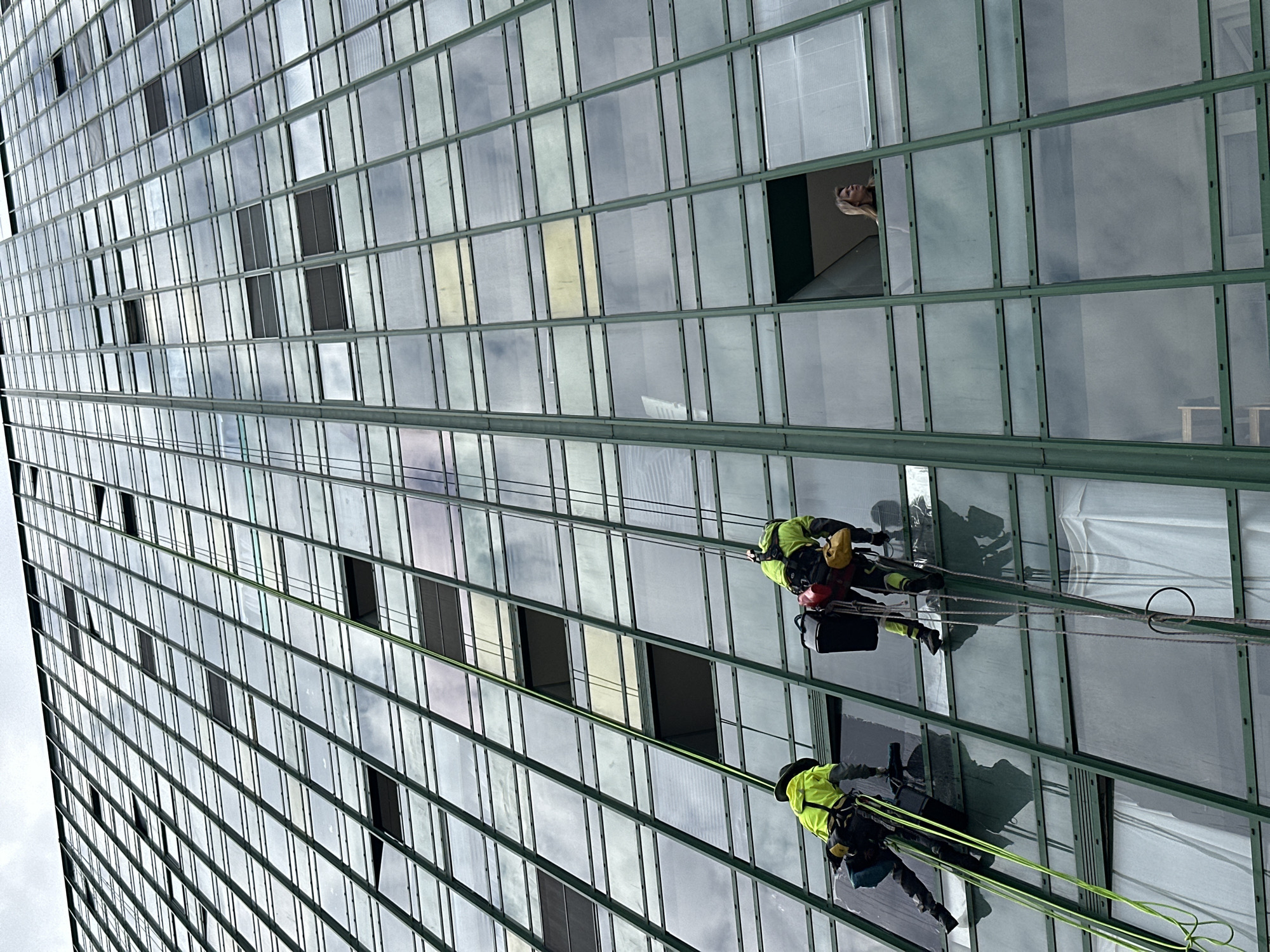 Window washers clean high-rise building facade in Murino, Russia