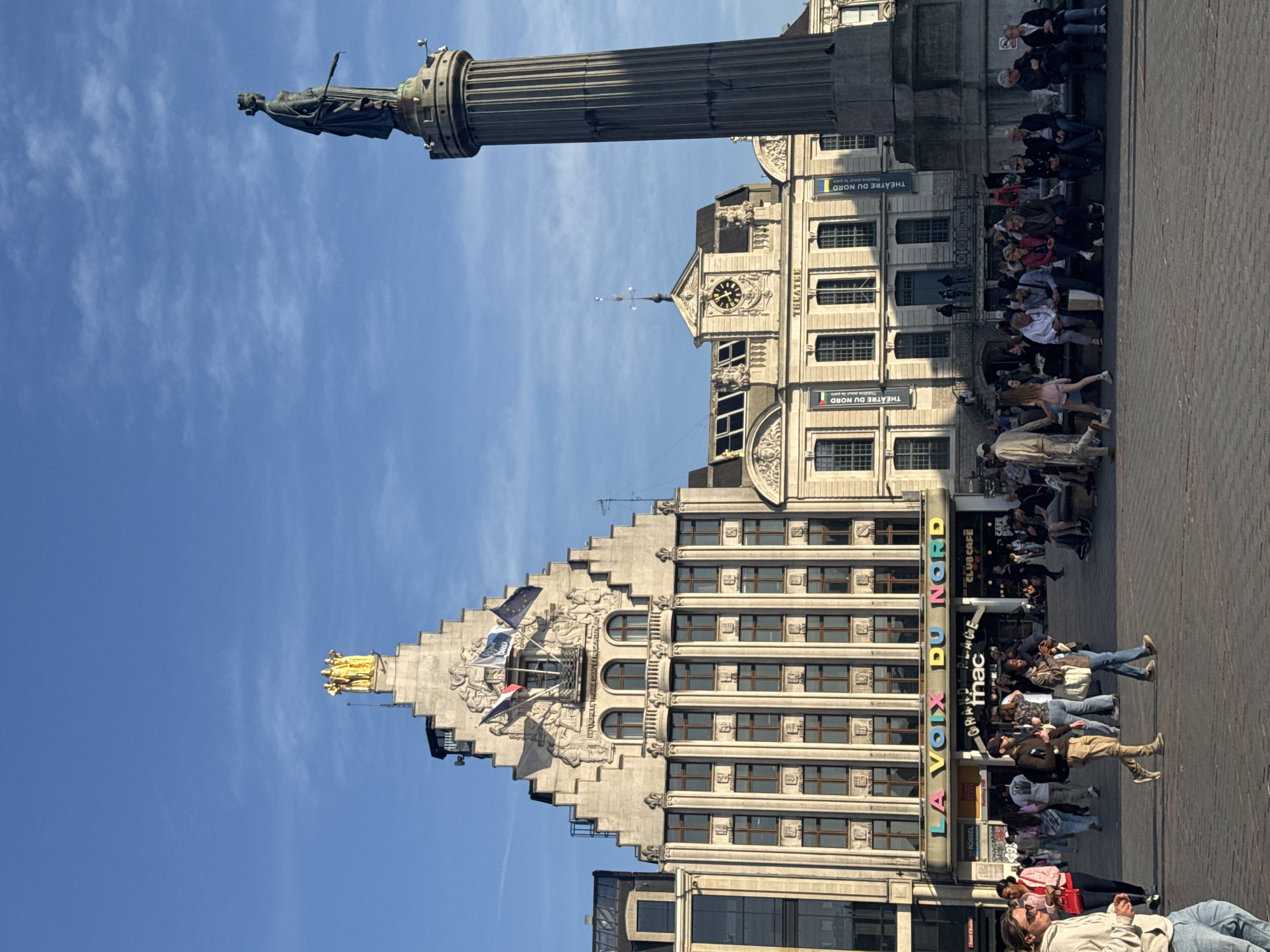 Saxophonist performs in historic Lille square on sunny afternoon