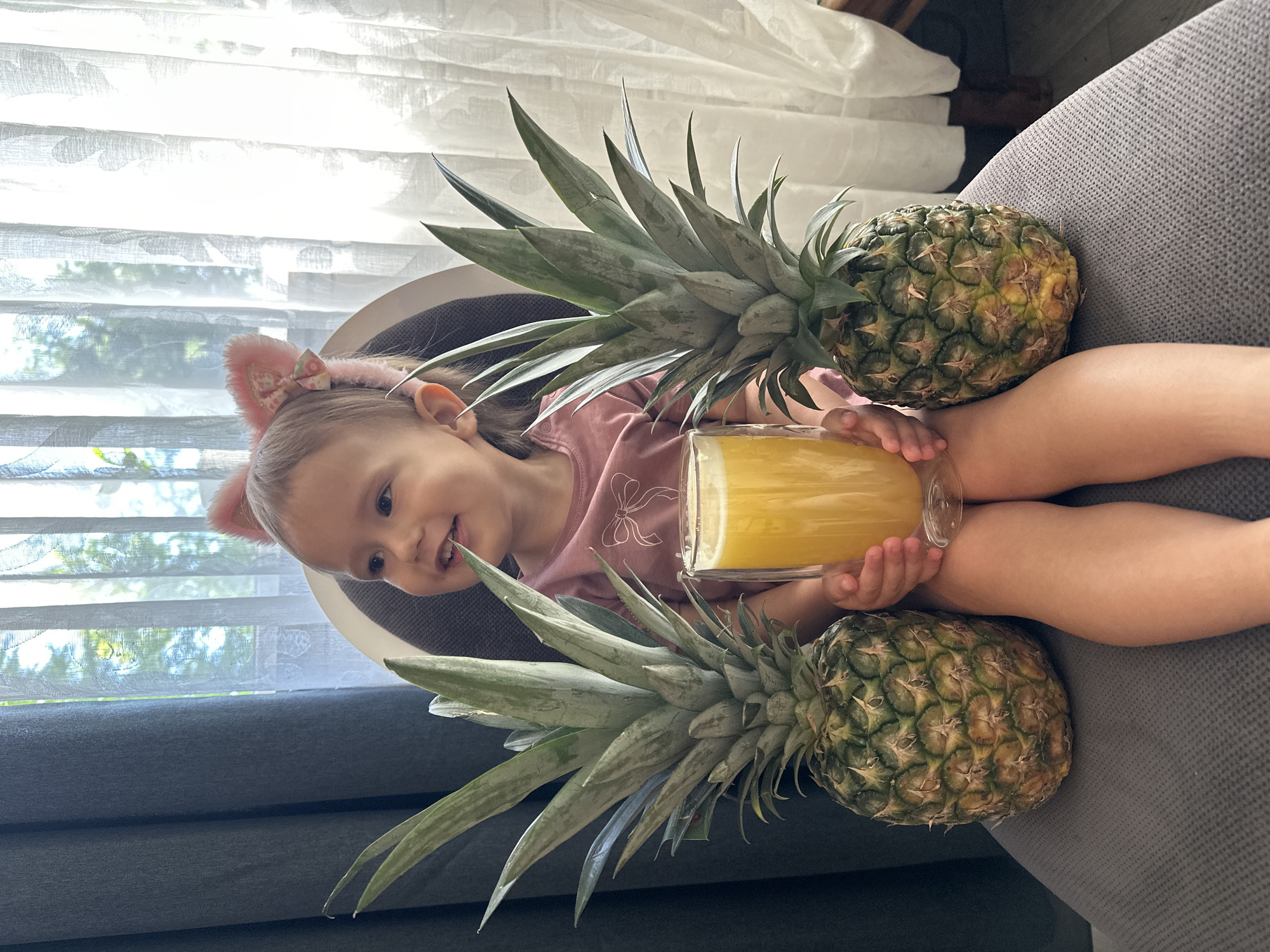Child with cat ears enjoys pineapples and juice in Wisła home