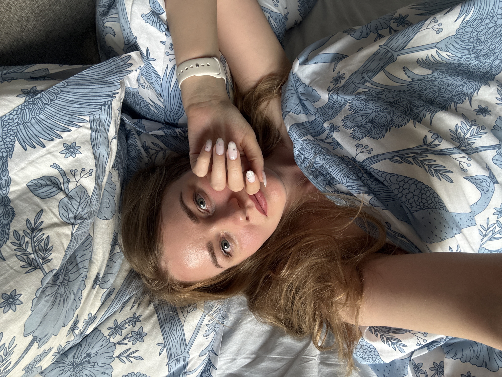 Woman photographed in bed during early morning in Saint Petersburg