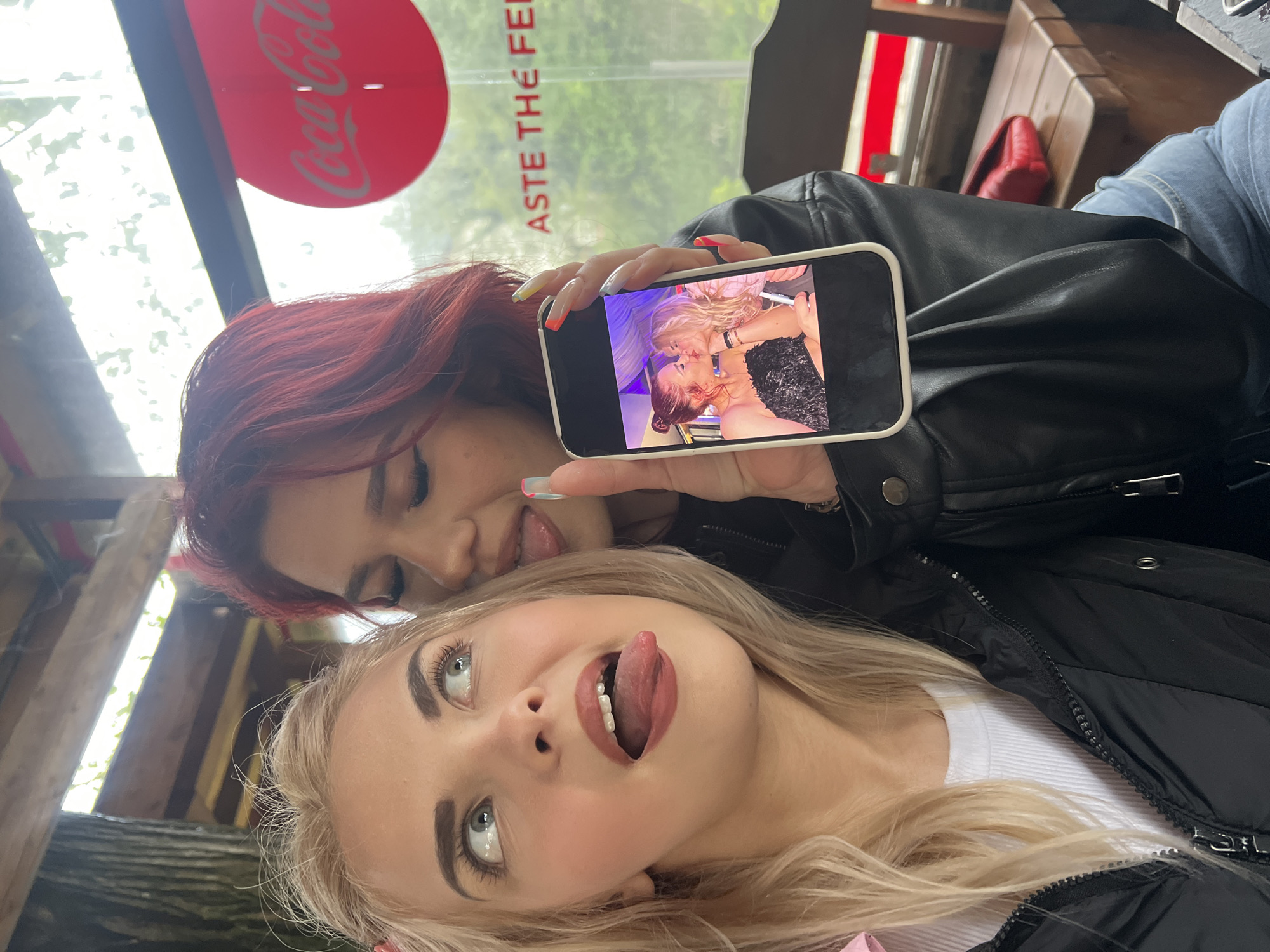 Two women share playful moment at cafe