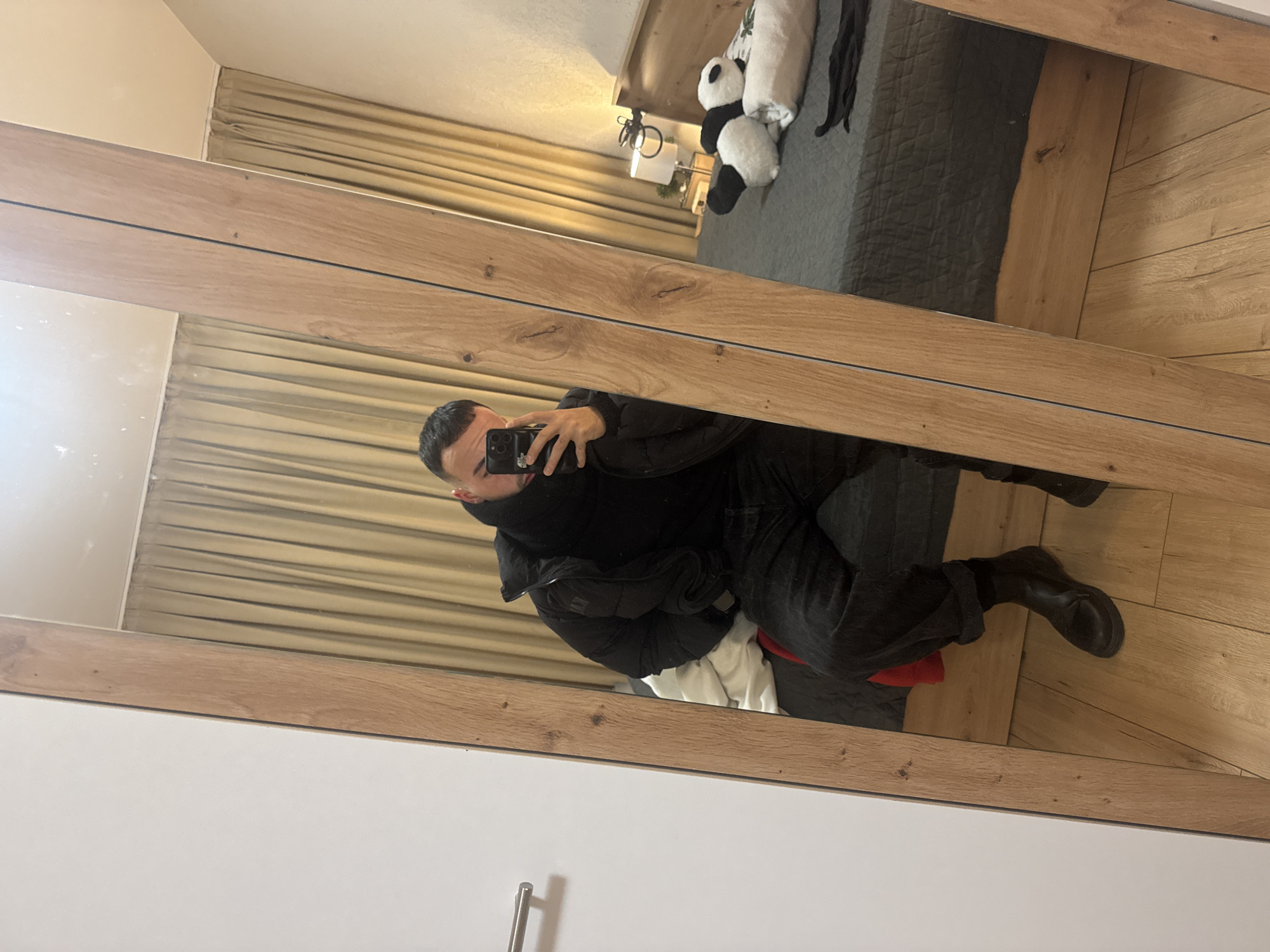 Person takes mirror selfie in Sofia bedroom