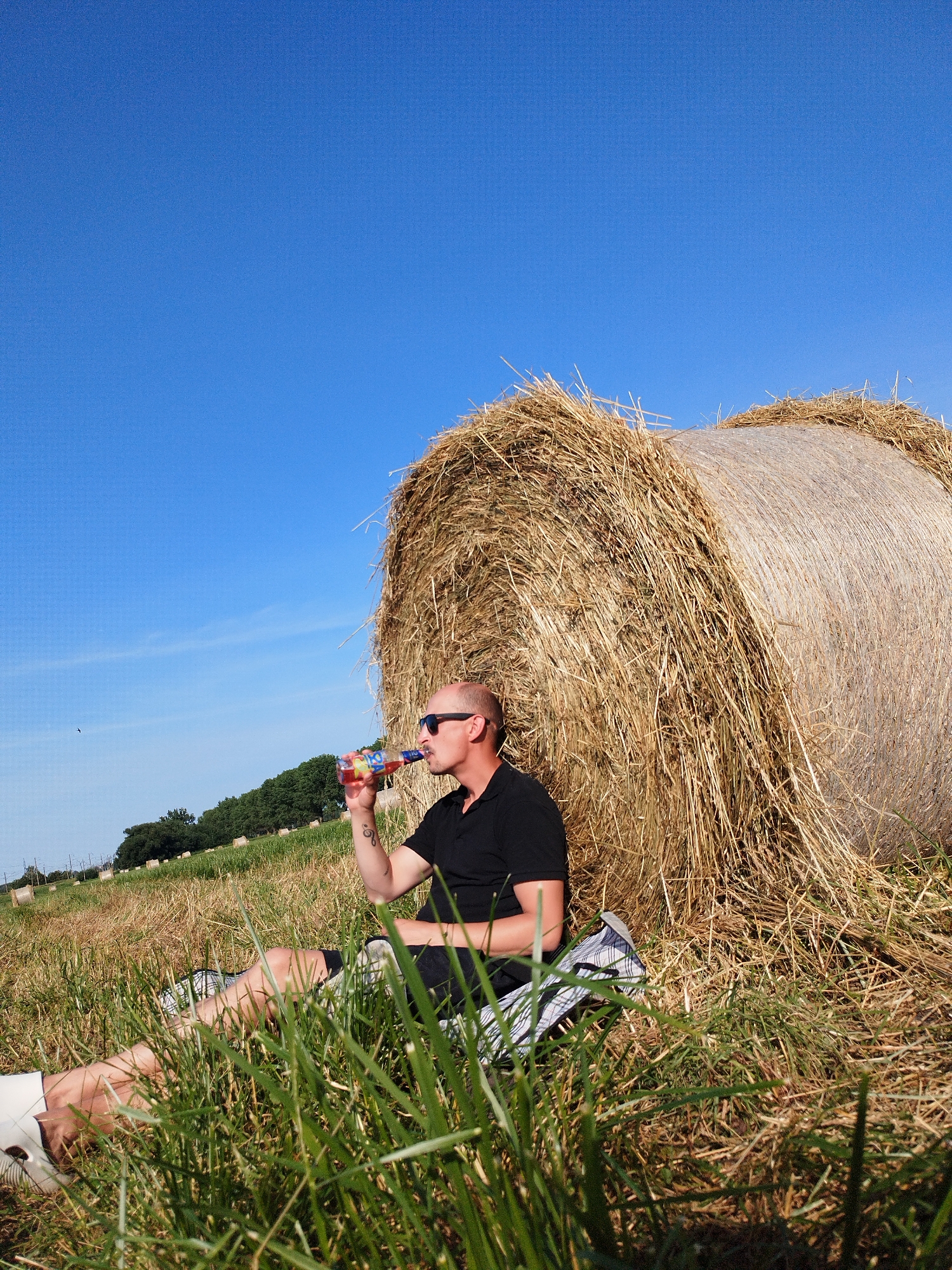 Sunny afternoon chilling by hay bales in an open field